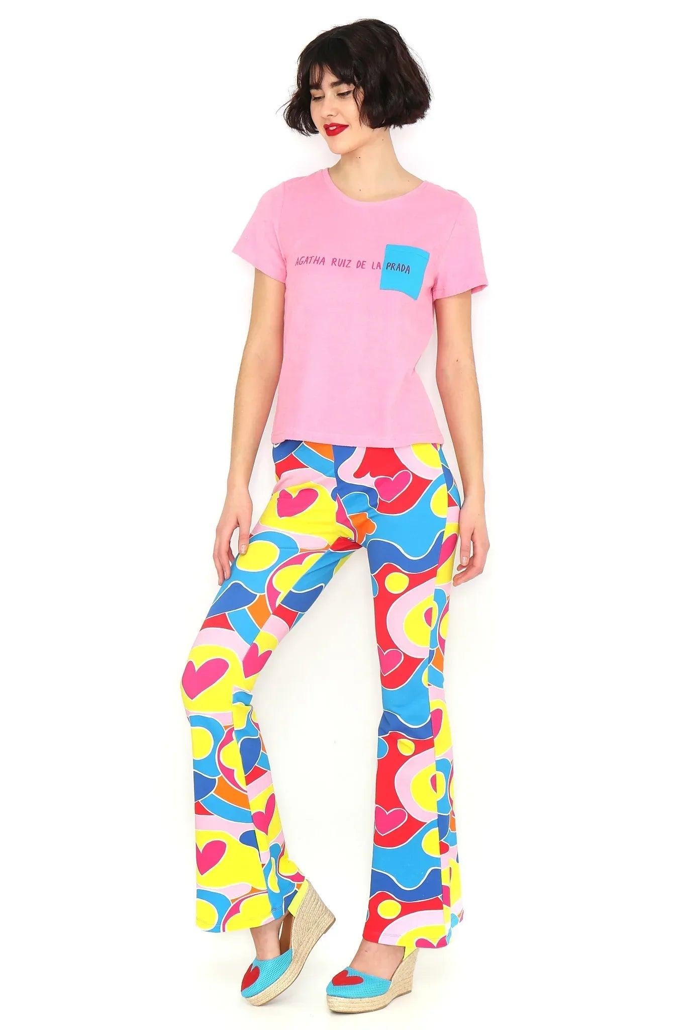 Camiseta rosa con bolsillo azul y texto estampado en la parte delantera.