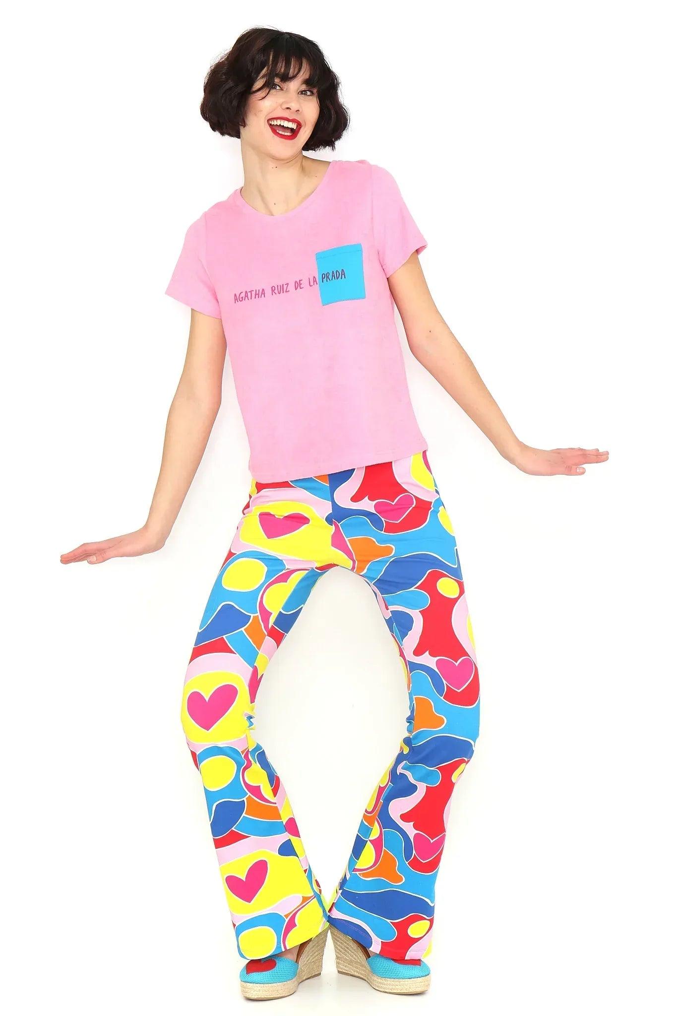 Camiseta rosa con bolsillo azul asimétrico y estampado frontal en el pecho.