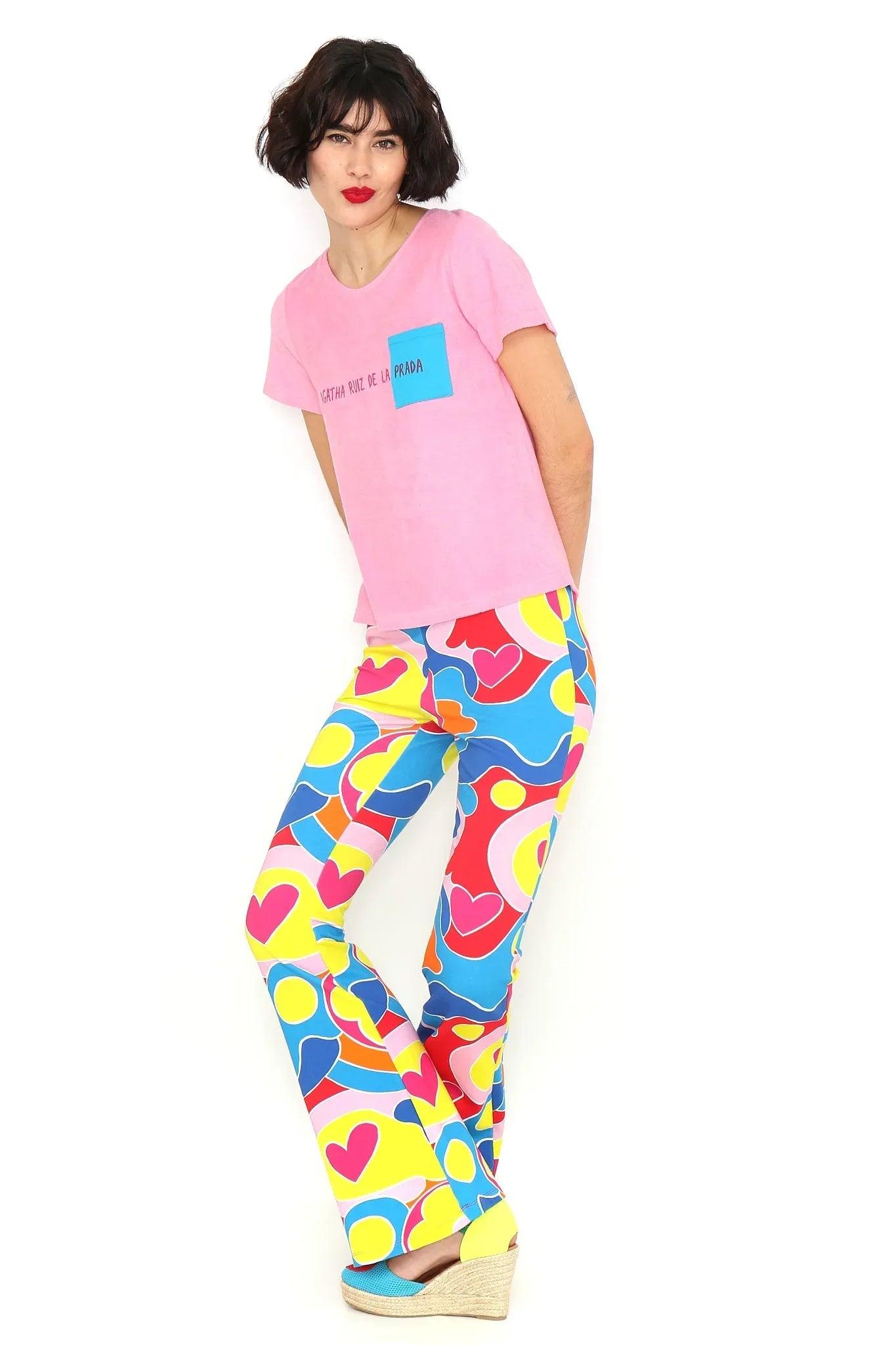 Camiseta rosa con bolsillo azul y estampado pequeño, con cuello redondo.