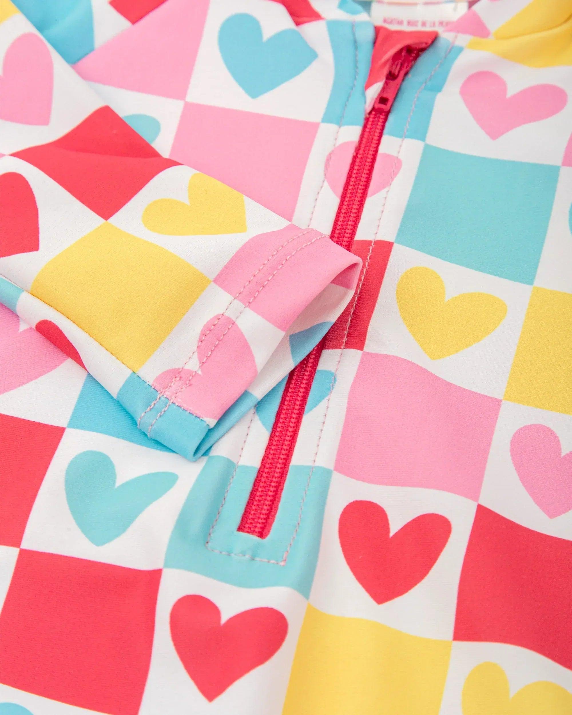 Bañador de licra con corazones multicolor; detalle de cremallera y puños