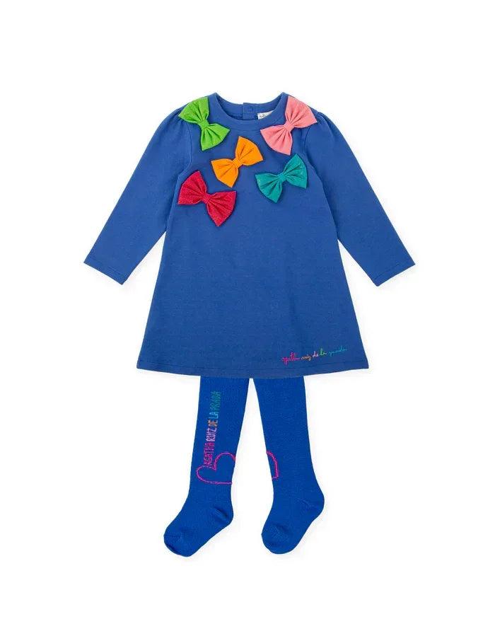 Conjunto: vestido azul de manga larga con lazos arcoíris en el pecho y leotardos.