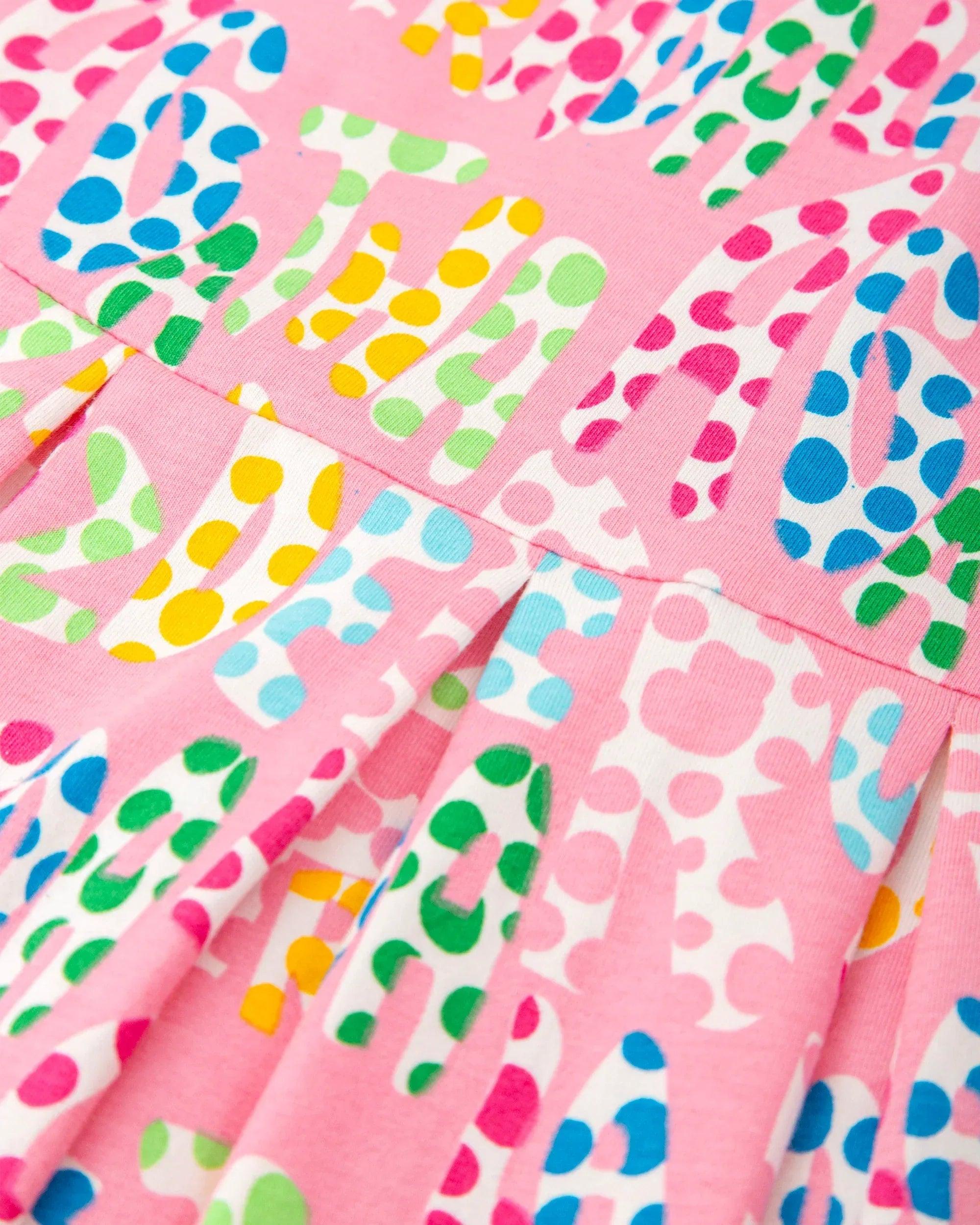Tela de vestido rosa con estampado de topos y corazones en colores vivos