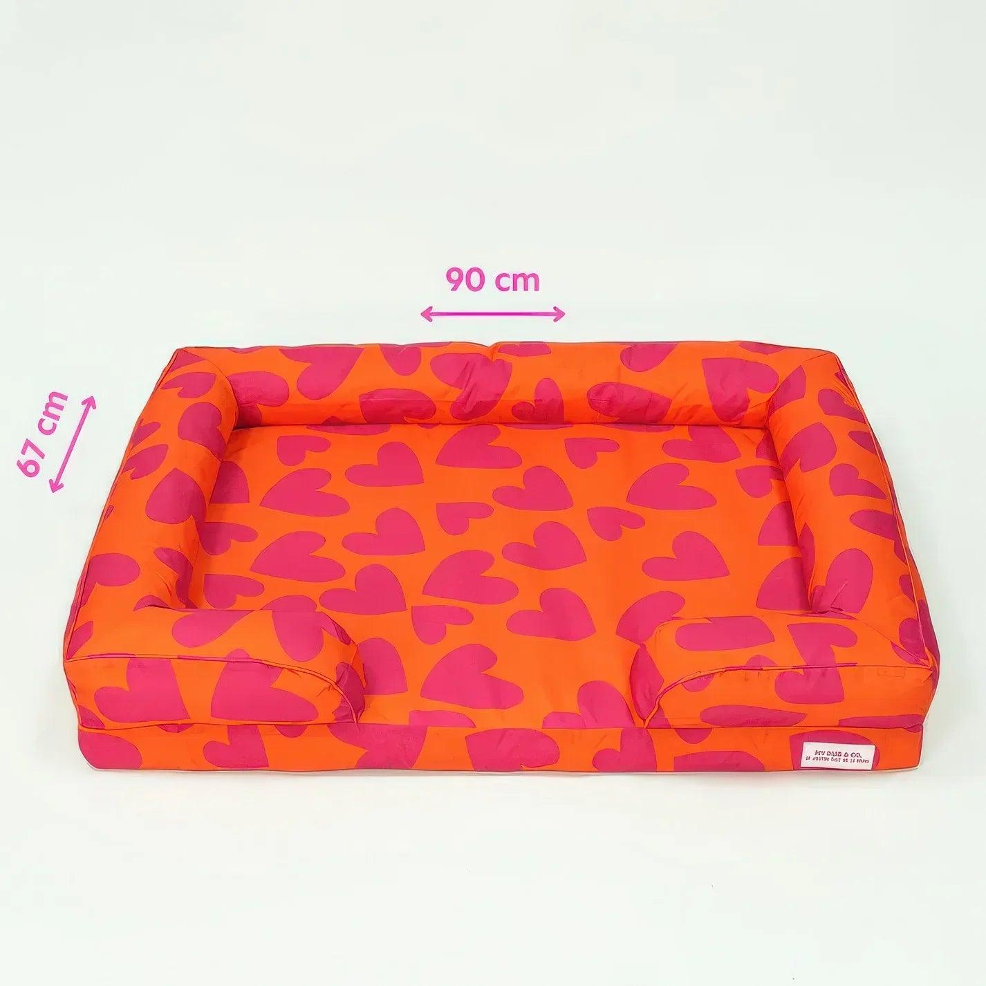 Cama acolchada para mascotas con patrón de corazones naranja y fucsia, 90 cm