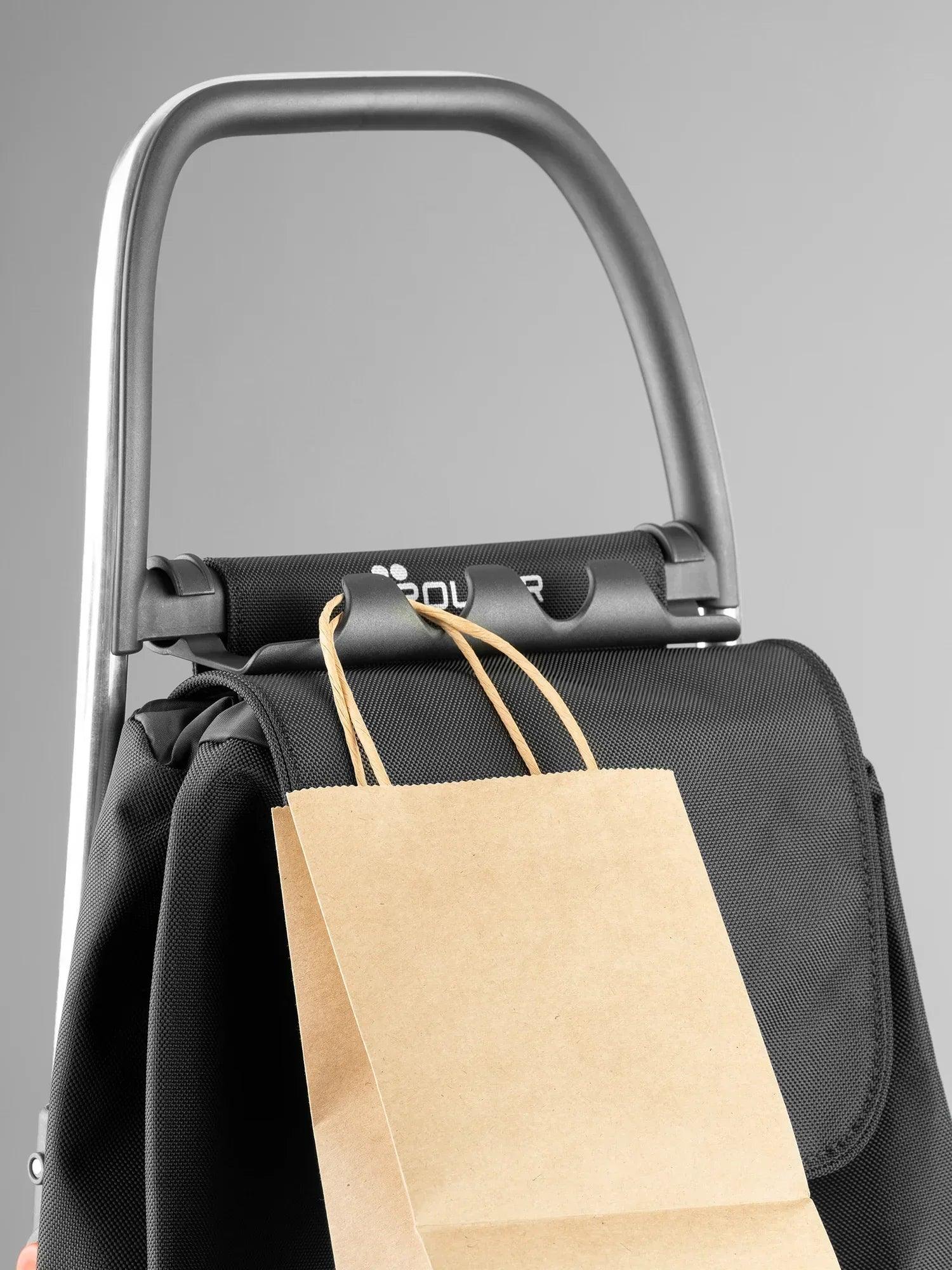Asiento acolchado negro de carro plegable con manillar y bolsa de papel