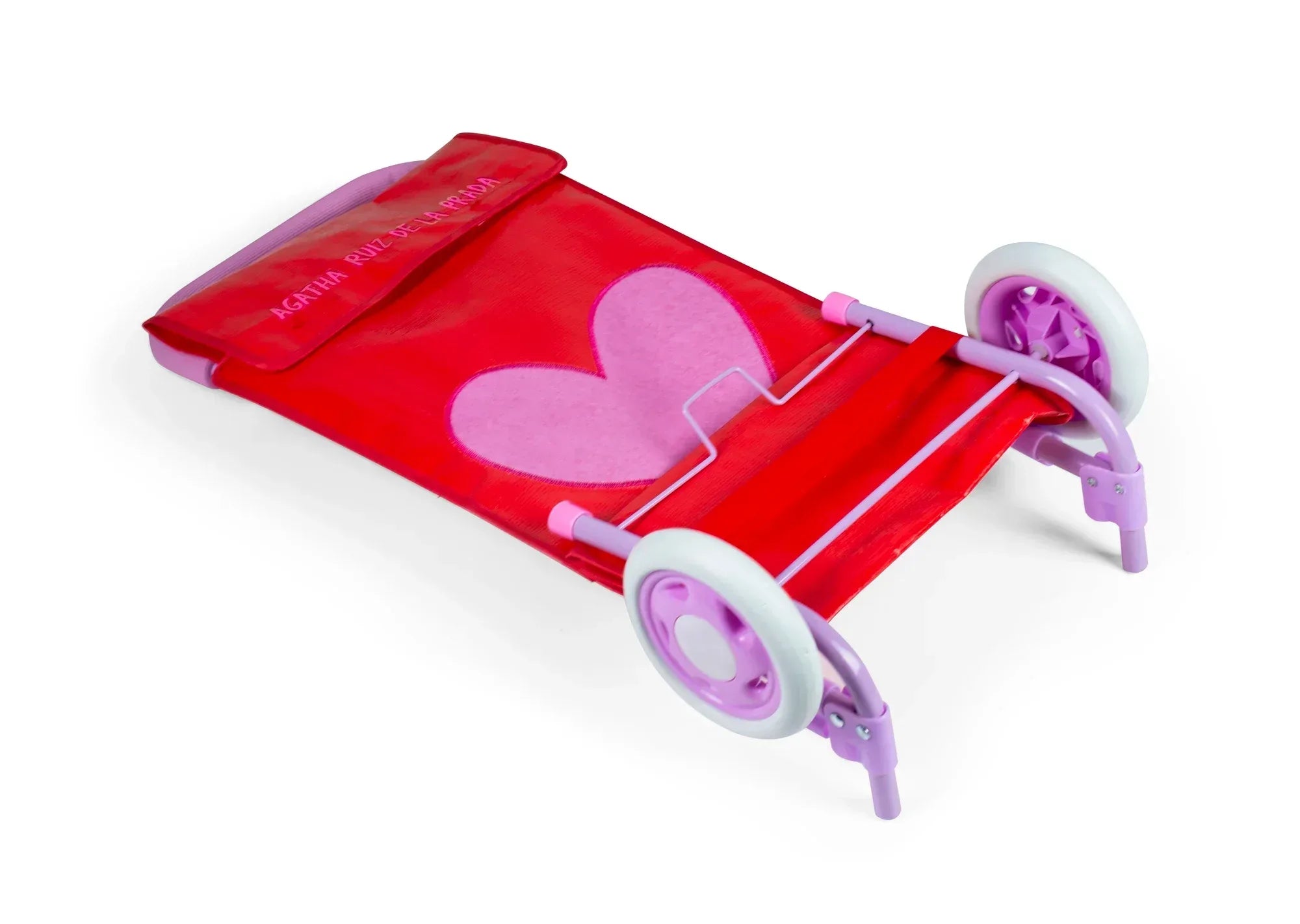 Carrito de compra rojo con corazón rosa, asas moradas y ruedas blancas