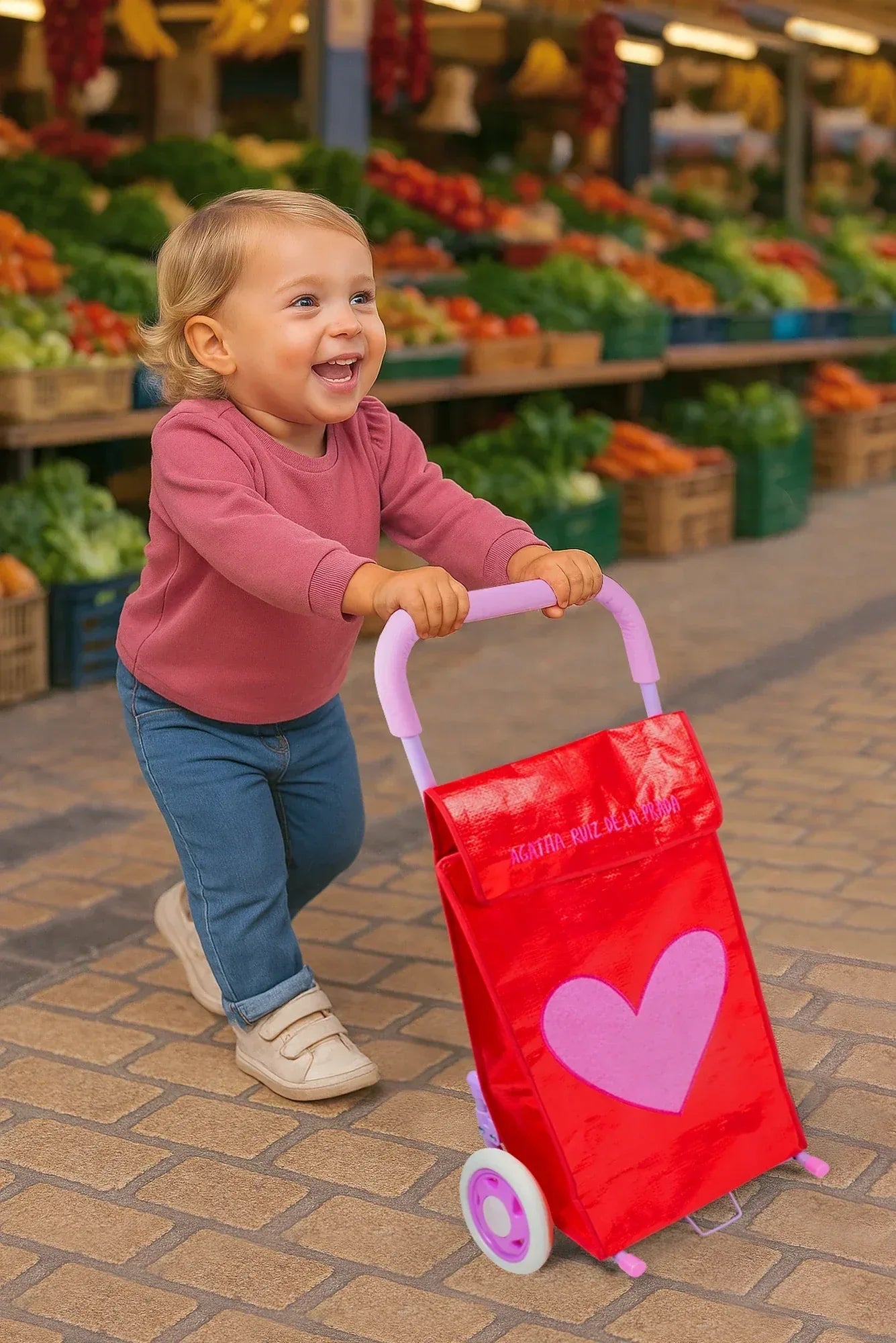 Carrito de compra rojo con corazón rosa, asas moradas y ruedas pequeñas