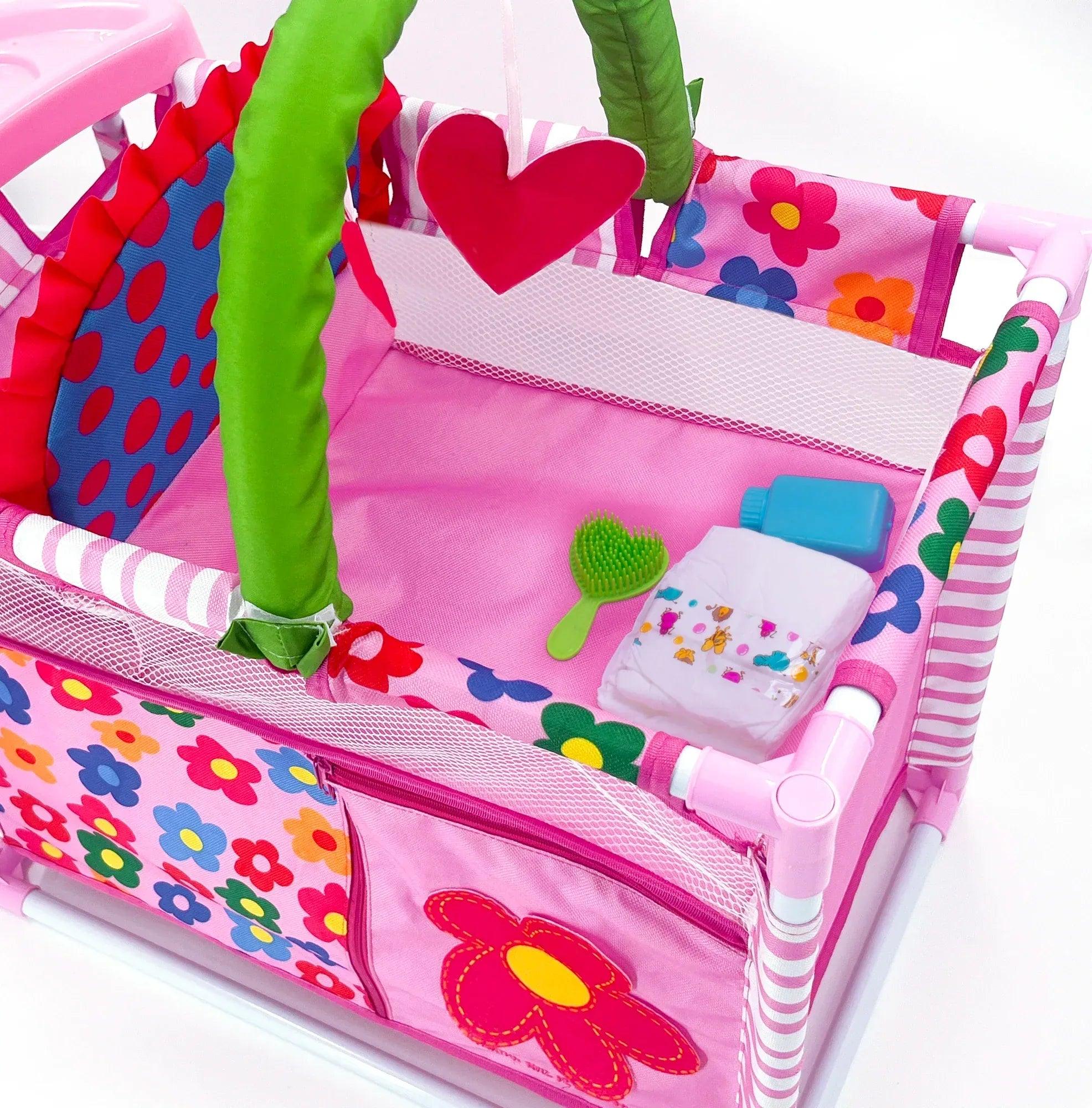 Cuna cambiadora rosa con asa verde y bolsillos laterales con motivo de mariposa
