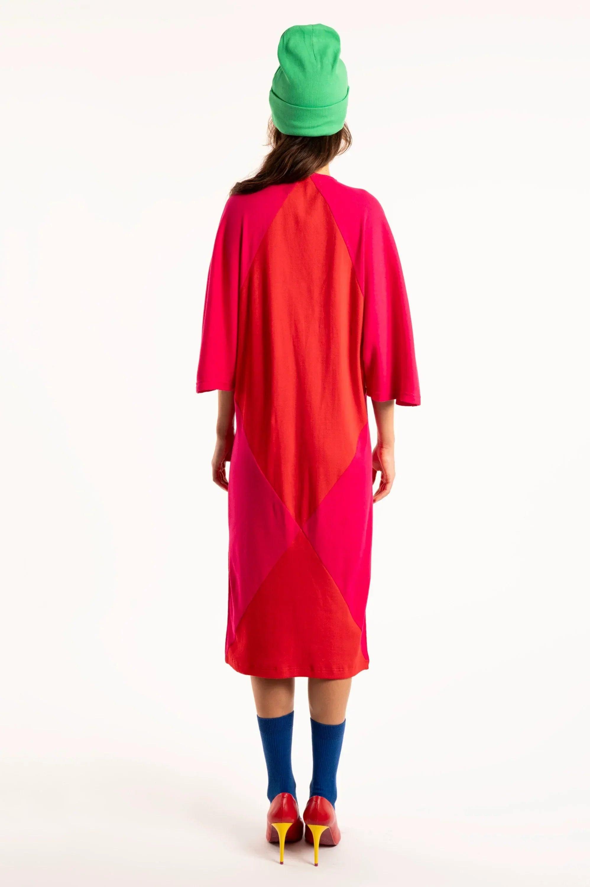 Vestido largo fucsia con paneles asimétricos diagonales y manga tres cuartos