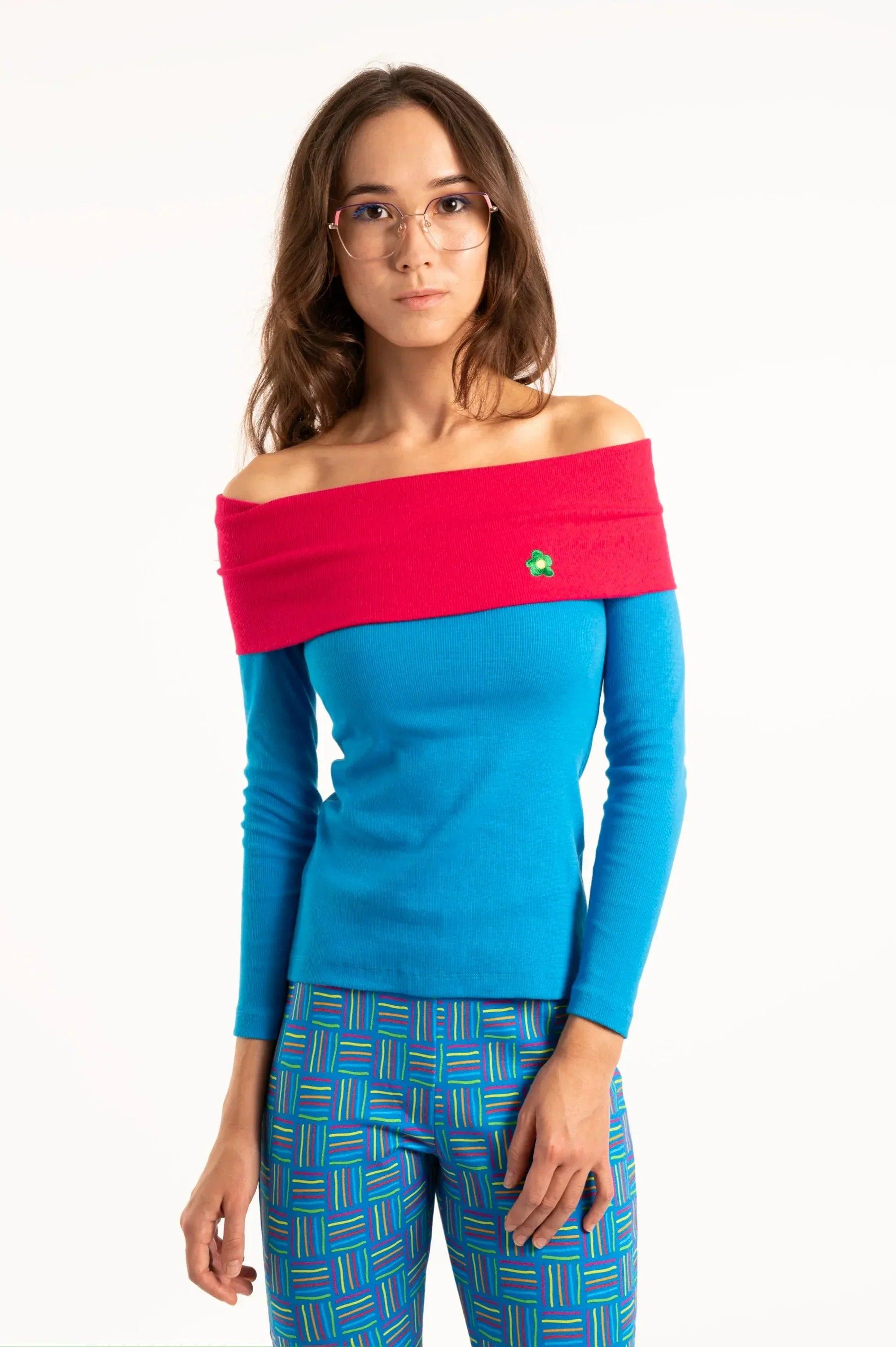 Camiseta azul con cuello barco fucsia y manga larga, flor verde bordada
