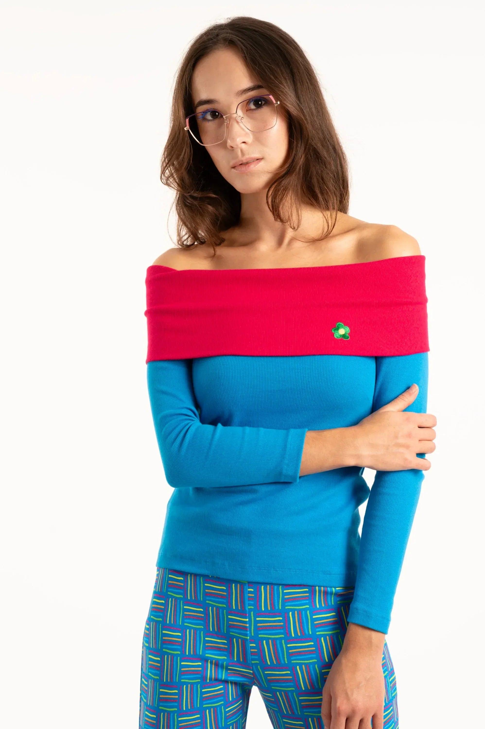 Camiseta azul con cuello barco fucsia, manga larga y flor verde bordada