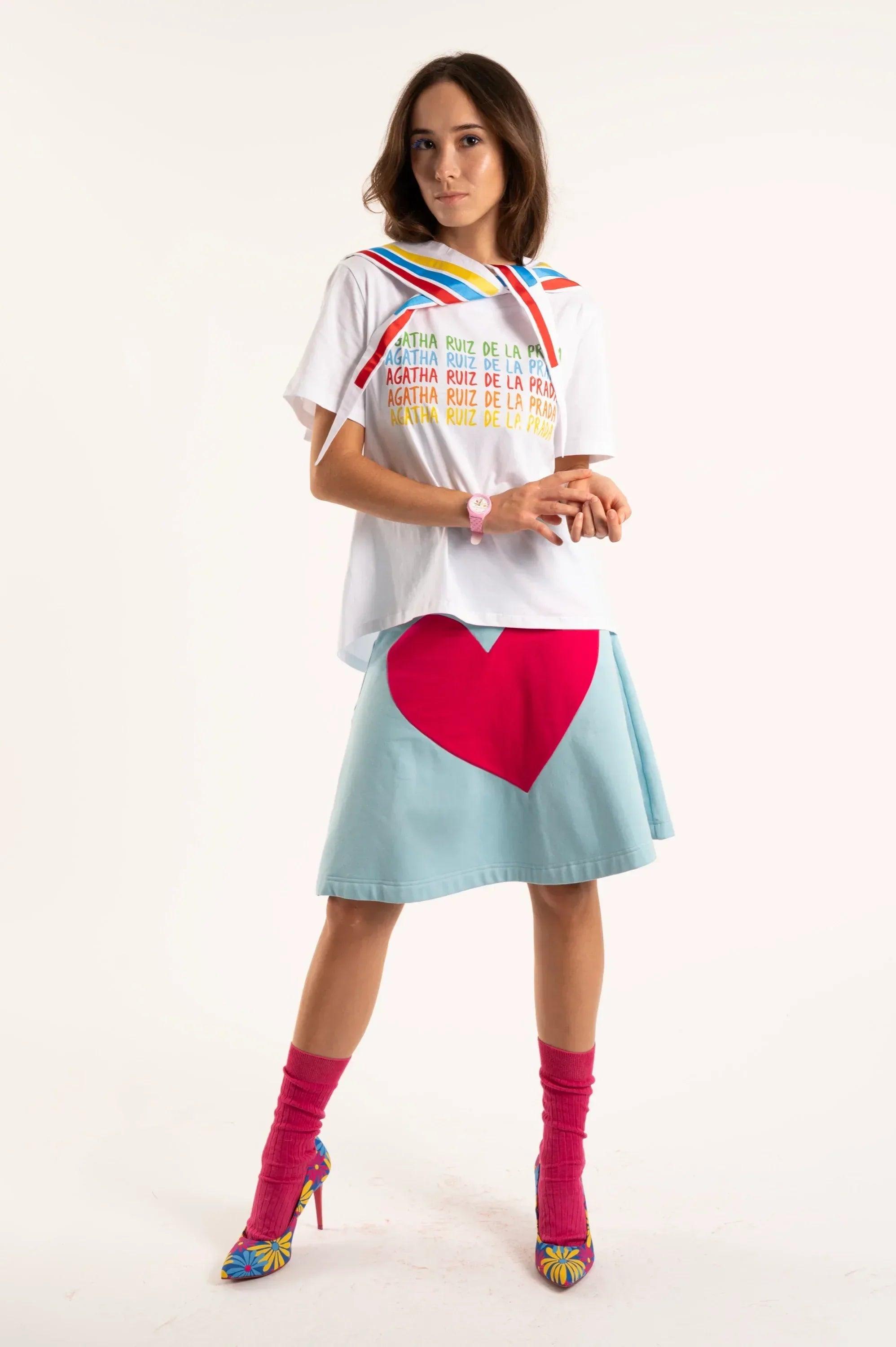 Camiseta blanca con rayas arcoíris en el cuello y texto AGATHA RUIZ DE LA PRADA