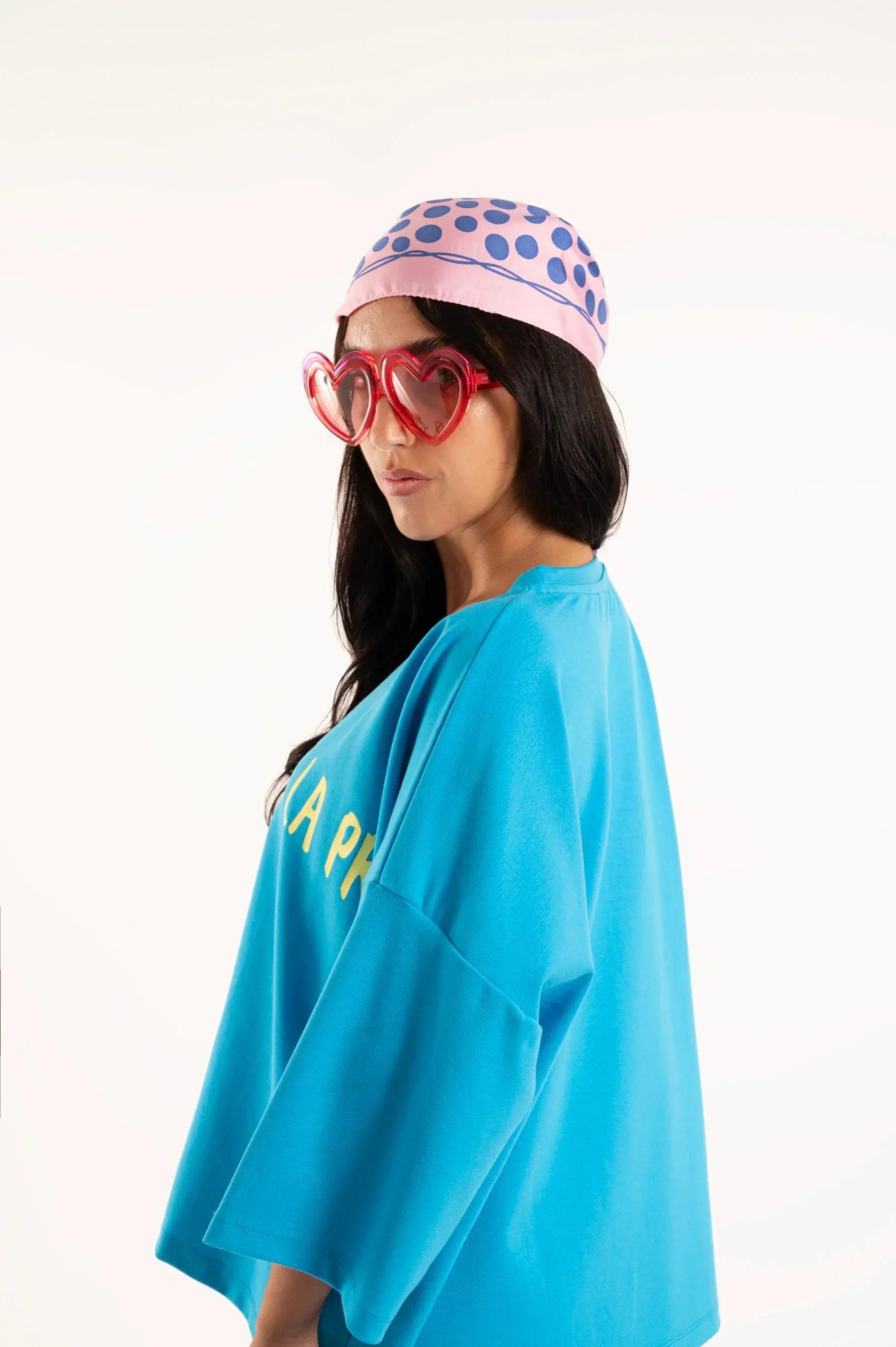 Camiseta oversize turquesa con estampado amarillo parcial y manga holgada