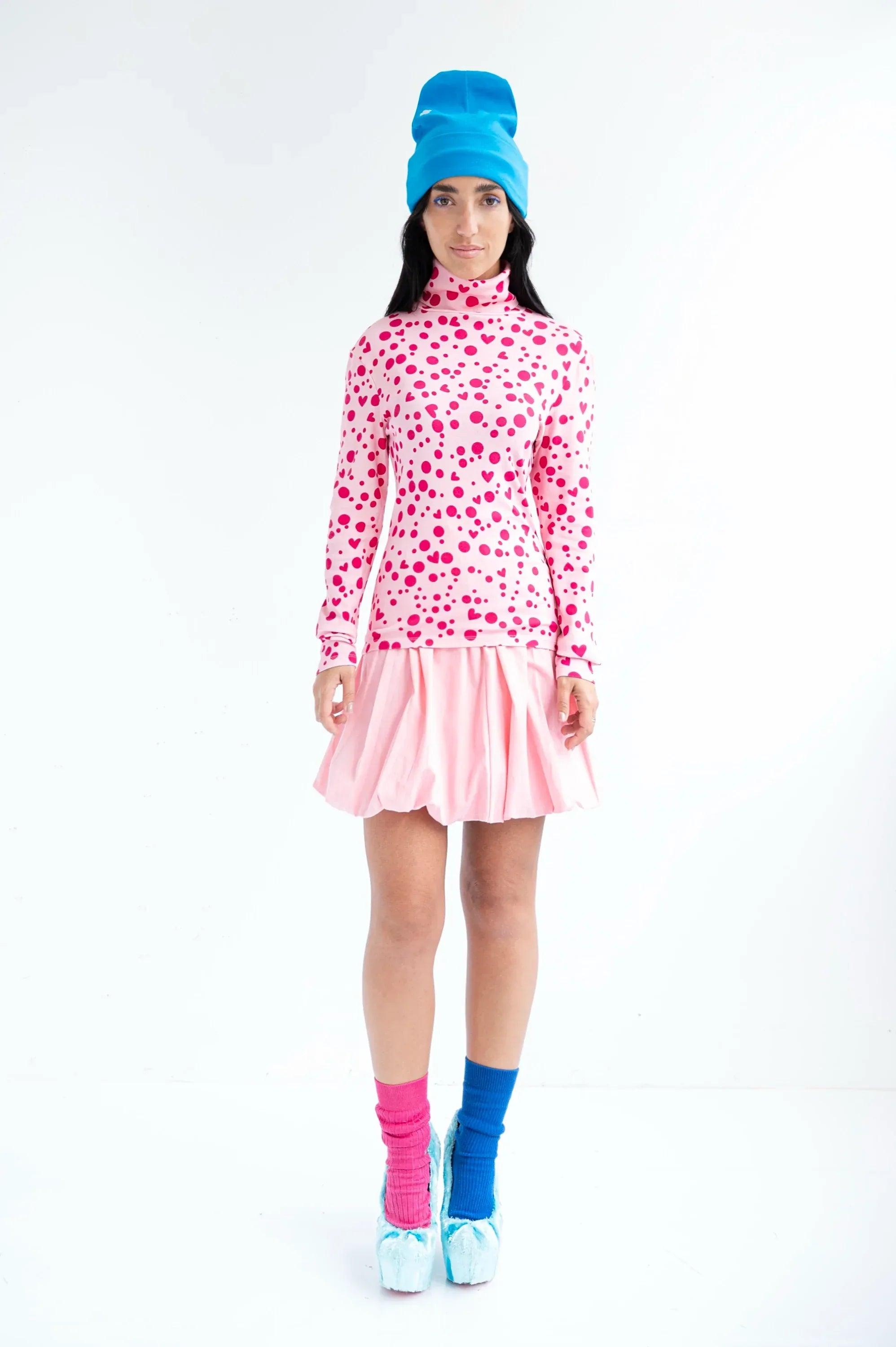 Camiseta de cuello alto rosa con lunares y corazones, manga larga y bajo fruncido