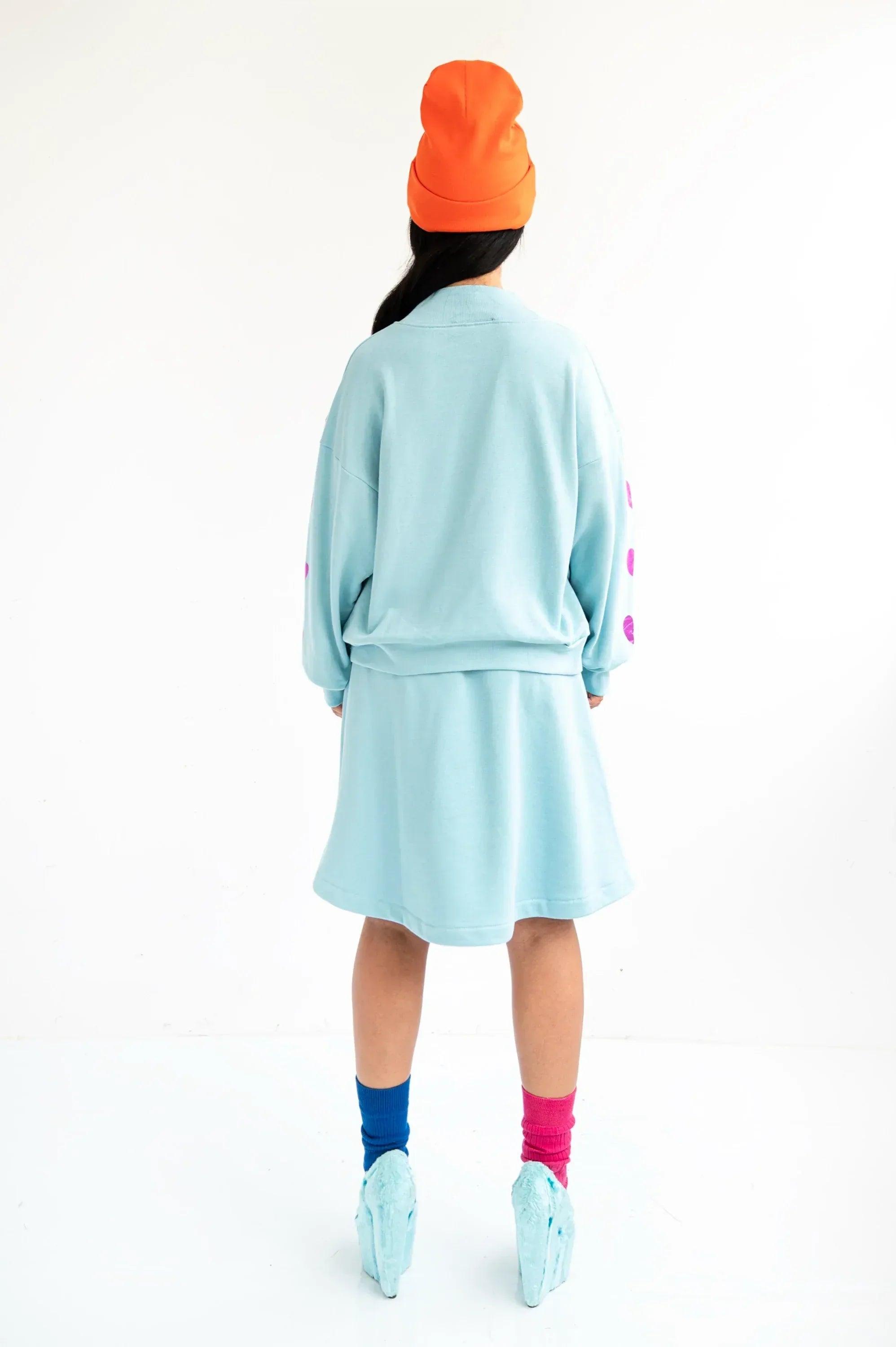 Sudadera azul vista trasera con puños elásticos y corazones en la manga