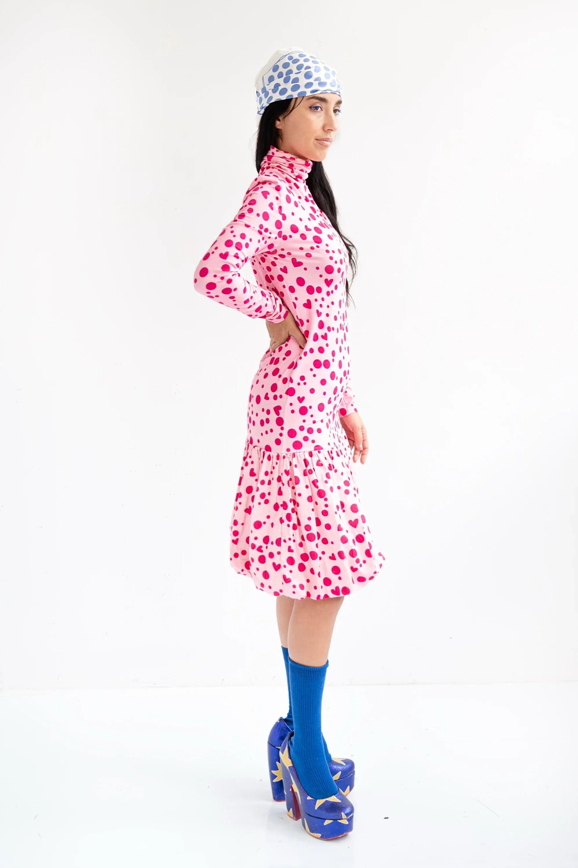 Vestido rosa con corazones, cuello alto, manga larga y falda con volantes