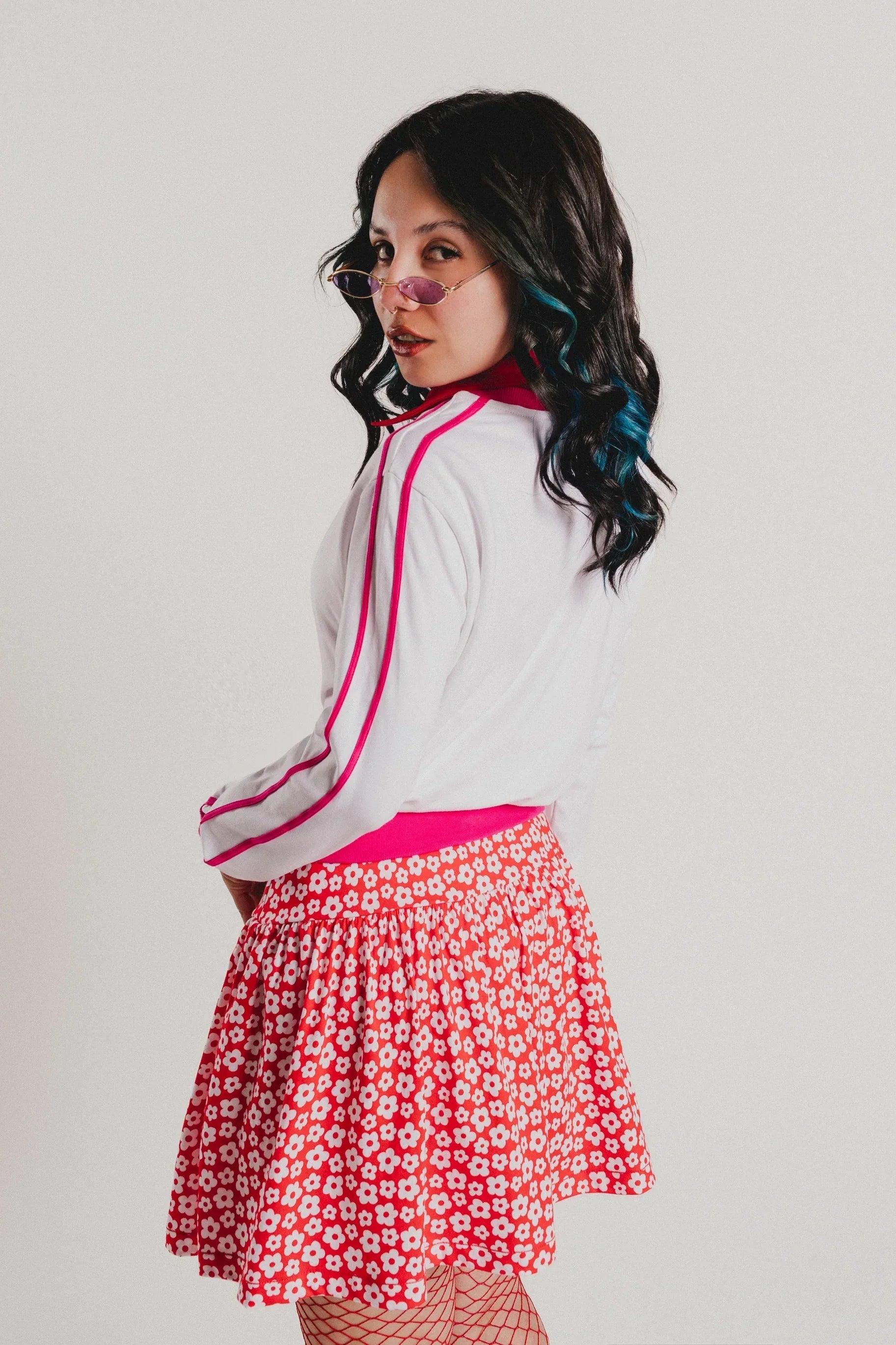 Sudadera blanca con ribete fucsia y falda roja estampada de flores