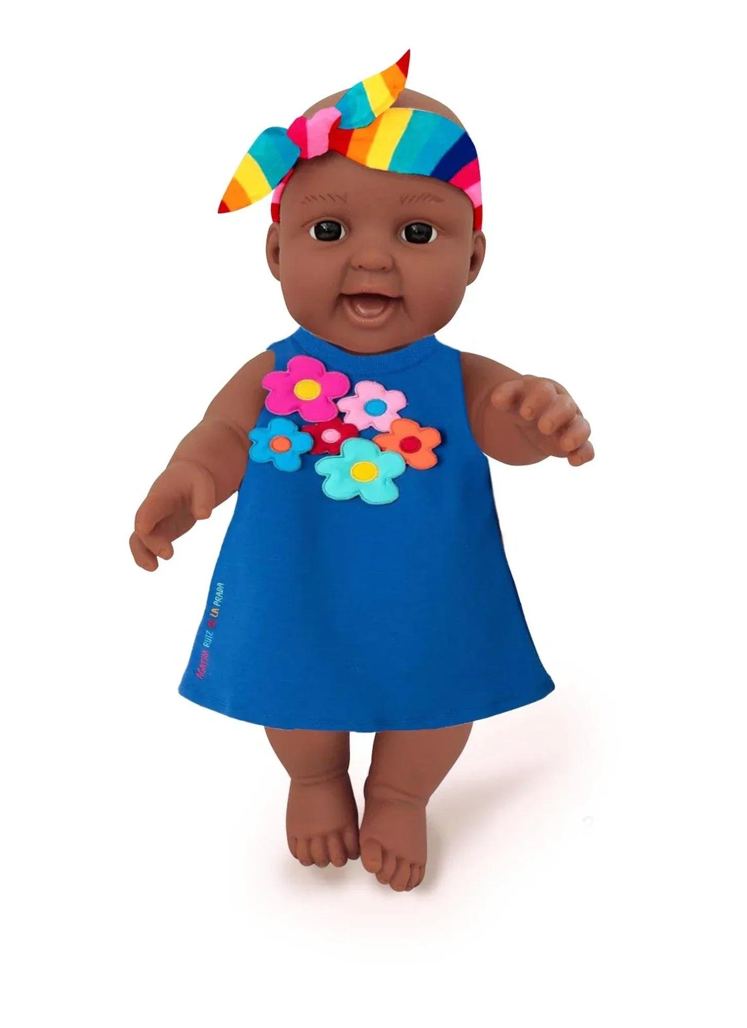 Muñeca con vestido azul sin mangas y diadema multicolor con lazos