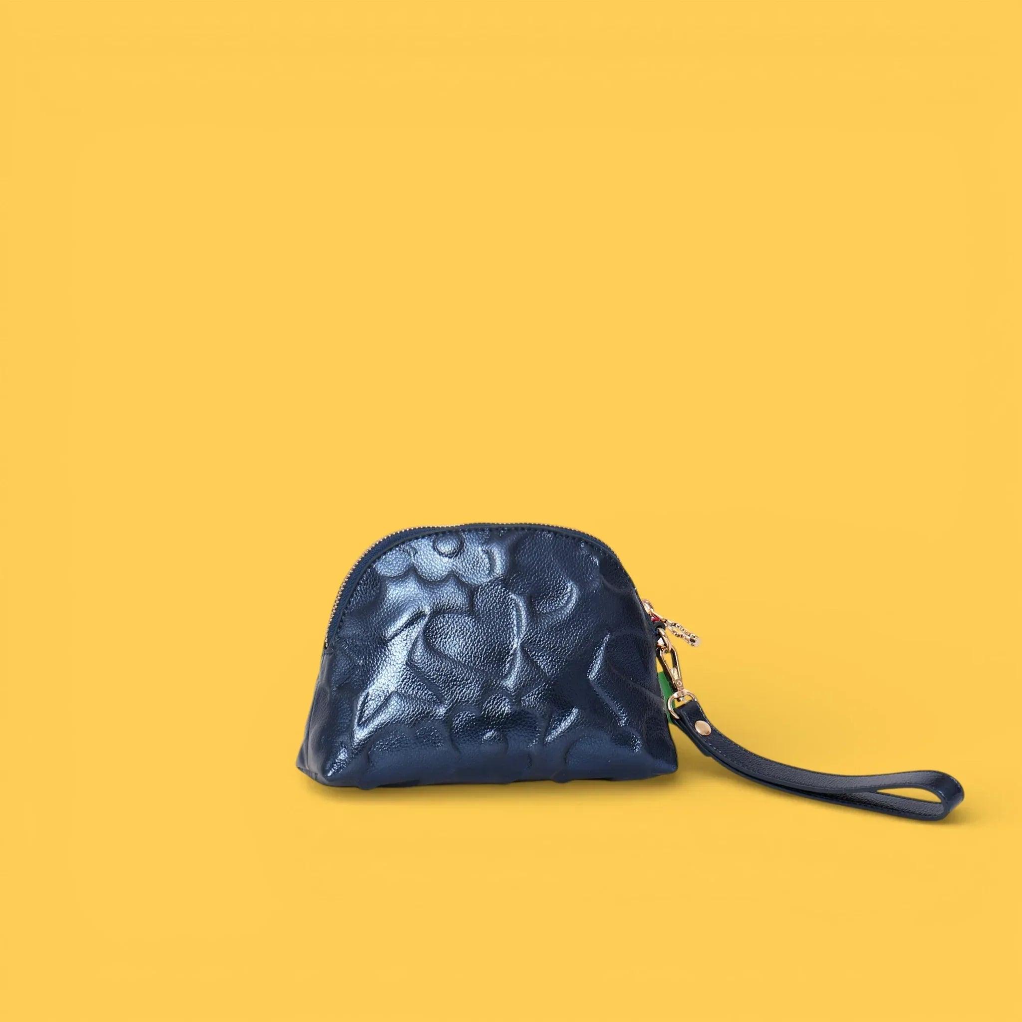 Neceser azul grabado con iconos en relieve y asa de muñeca