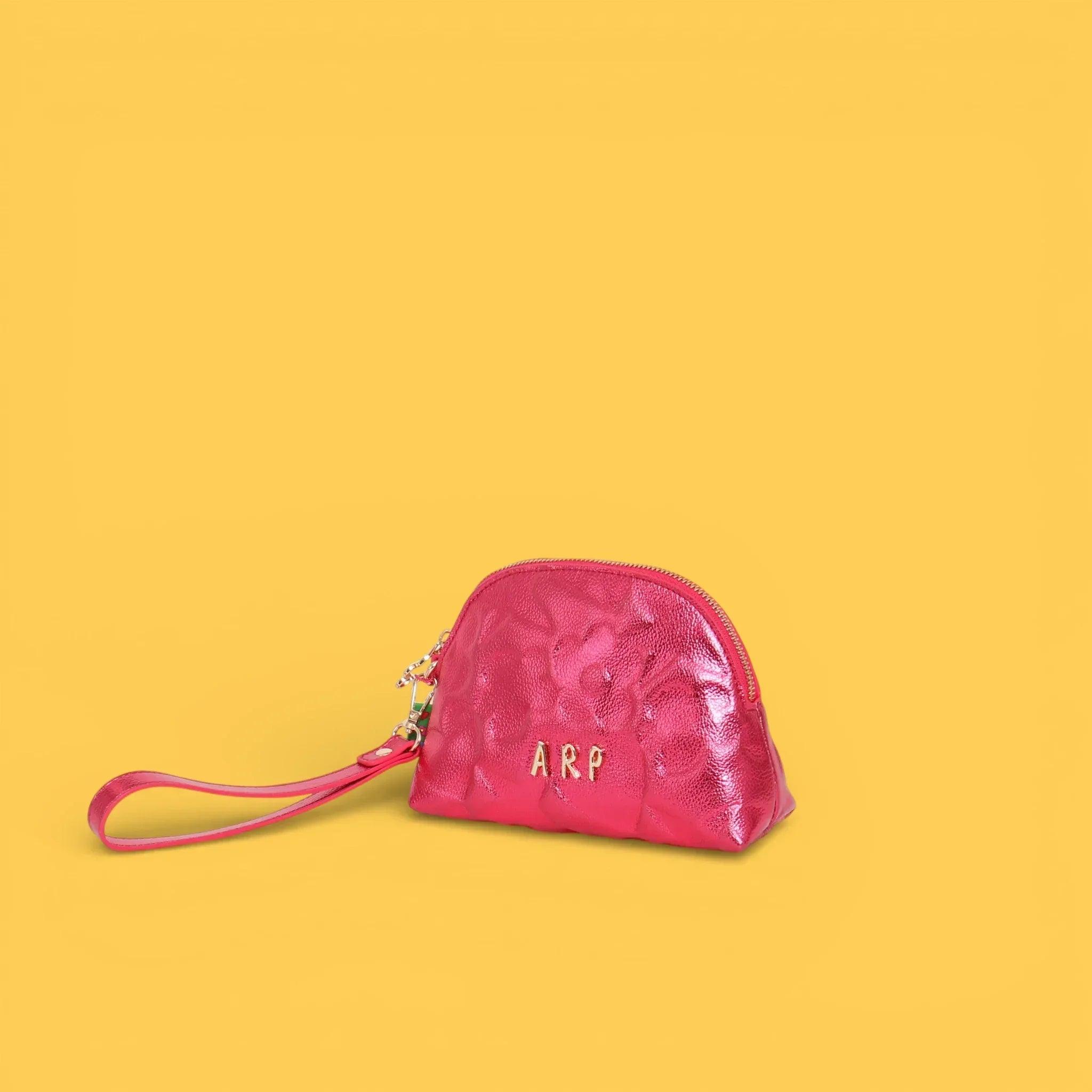 Neceser fucsia con grabado y logo al frente, asa de mano y cremallera superior