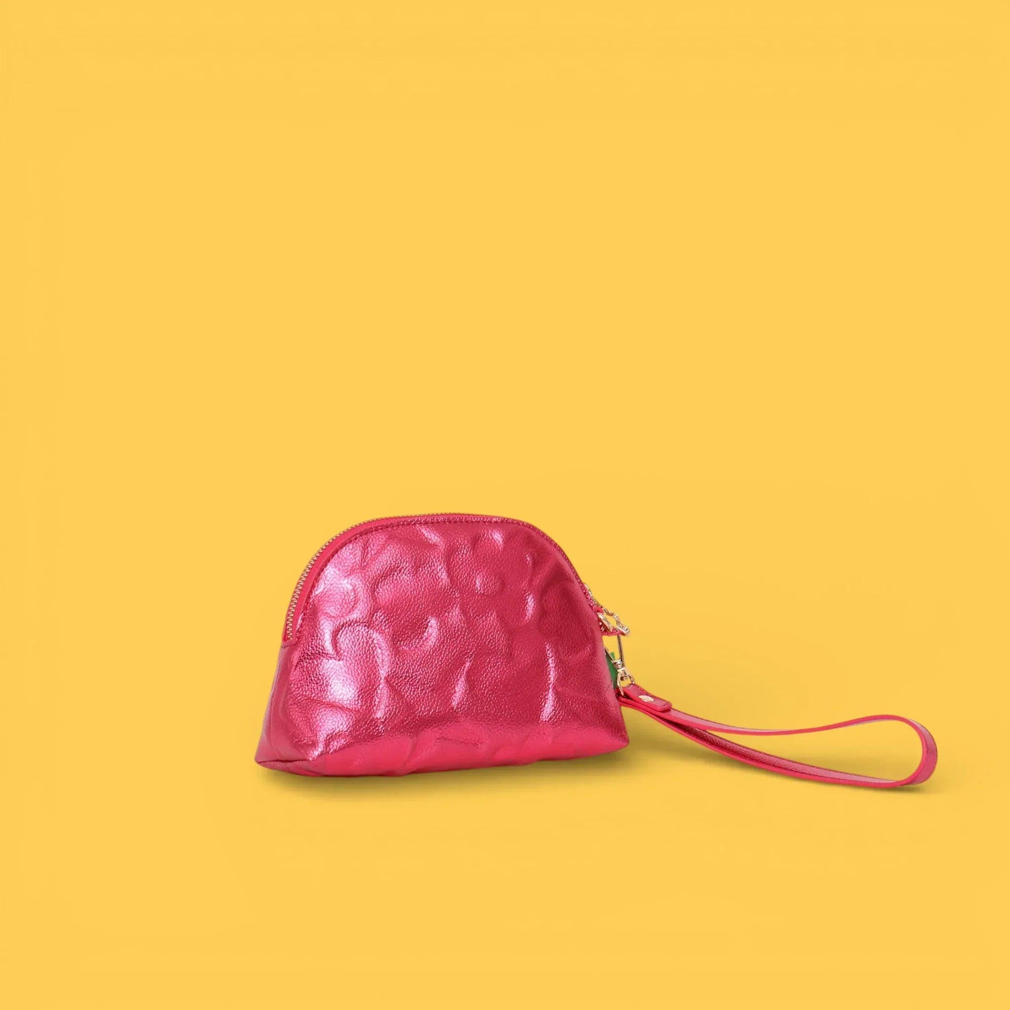 Neceser fucsia acolchado con grabado de iconos y cordón colgante, cierre con cremallera