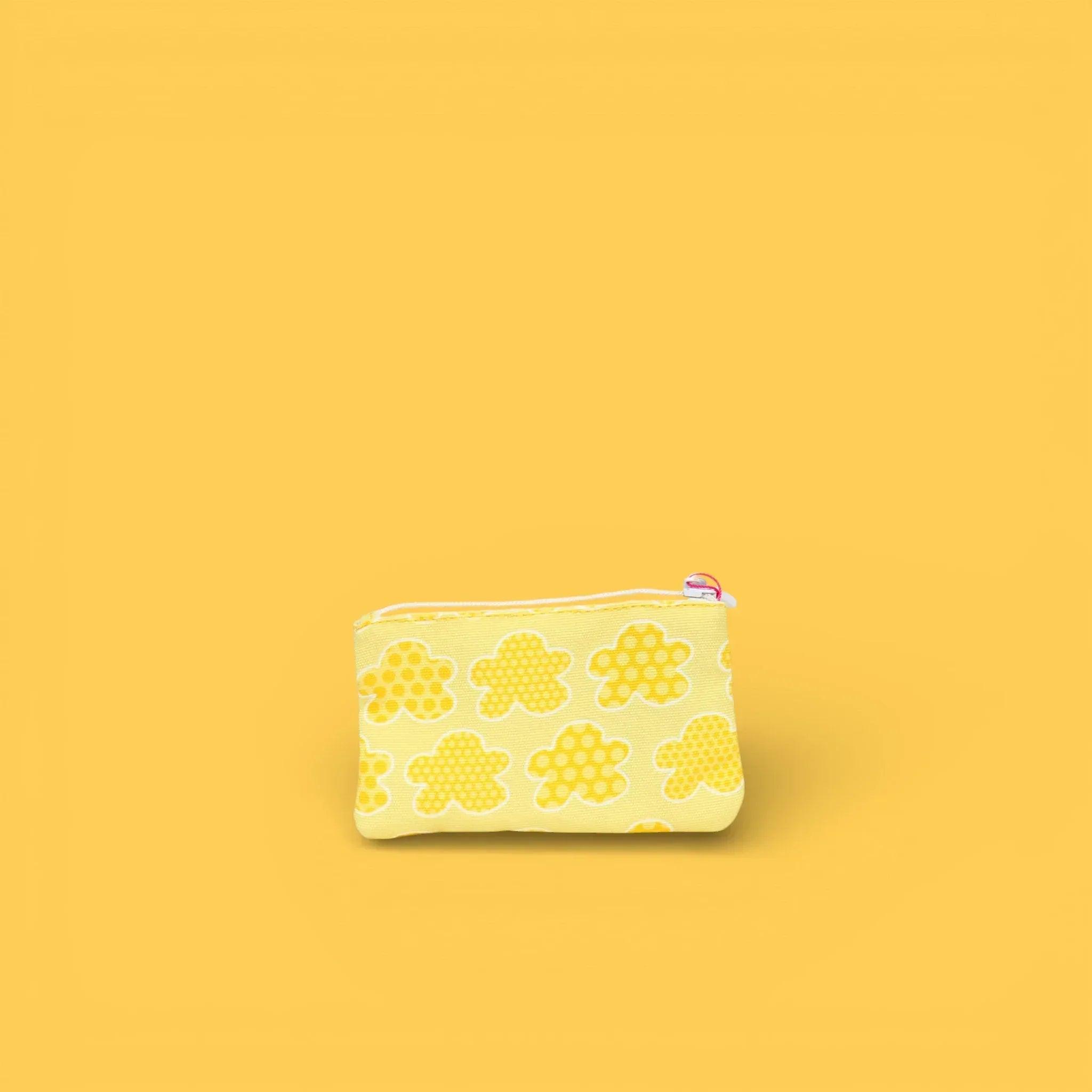 Monedero con cremallera estampado crema con nubes amarillas, vista lateral.