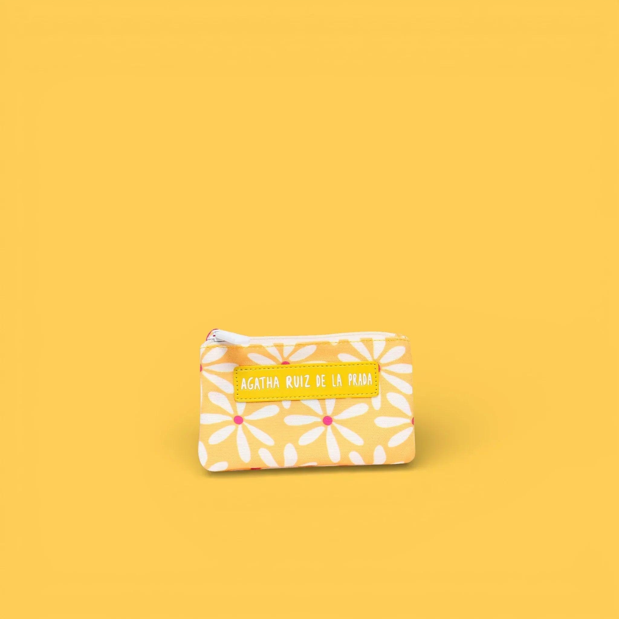 Monedero con cremallera estampado blanco con flores naranjas y etiqueta amarilla.