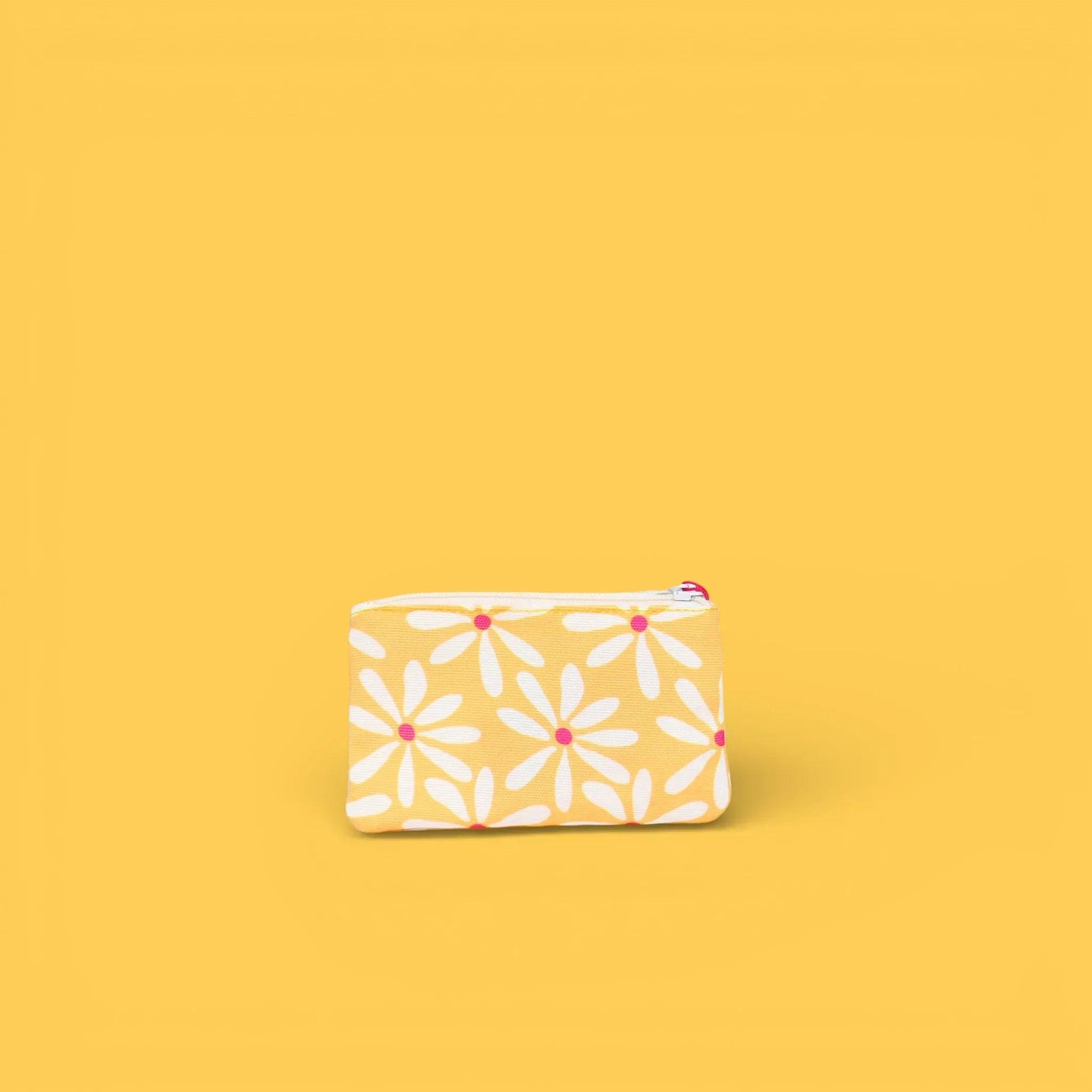 Monedero con cremallera estampado blanco con margaritas naranjas y rosas, diseño repetido.