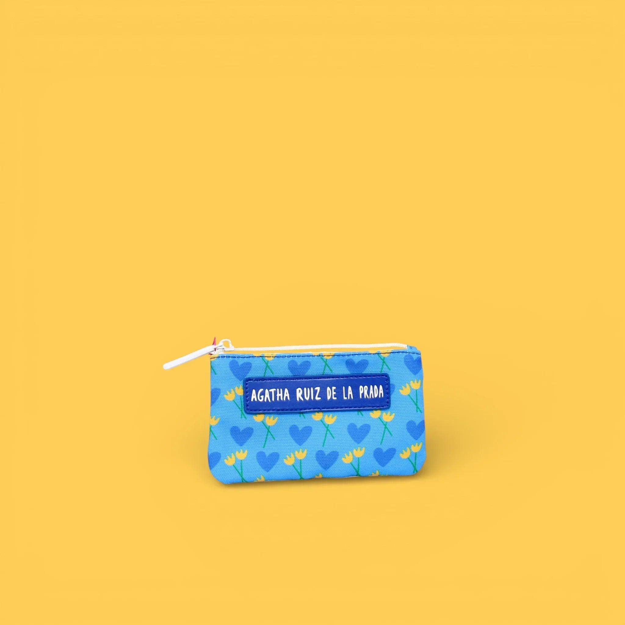 Monedero con cremallera estampado azul con corazones y flores, con etiqueta central.