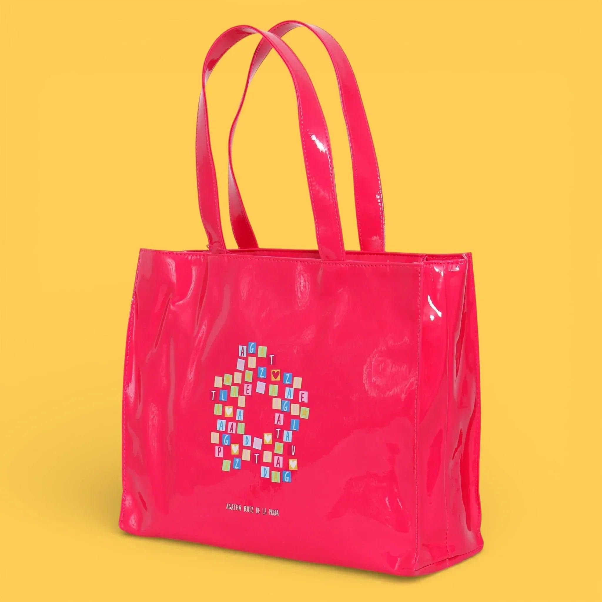 Bolsa shopper fucsia brillante con asas dobles y logotipo en el centro.