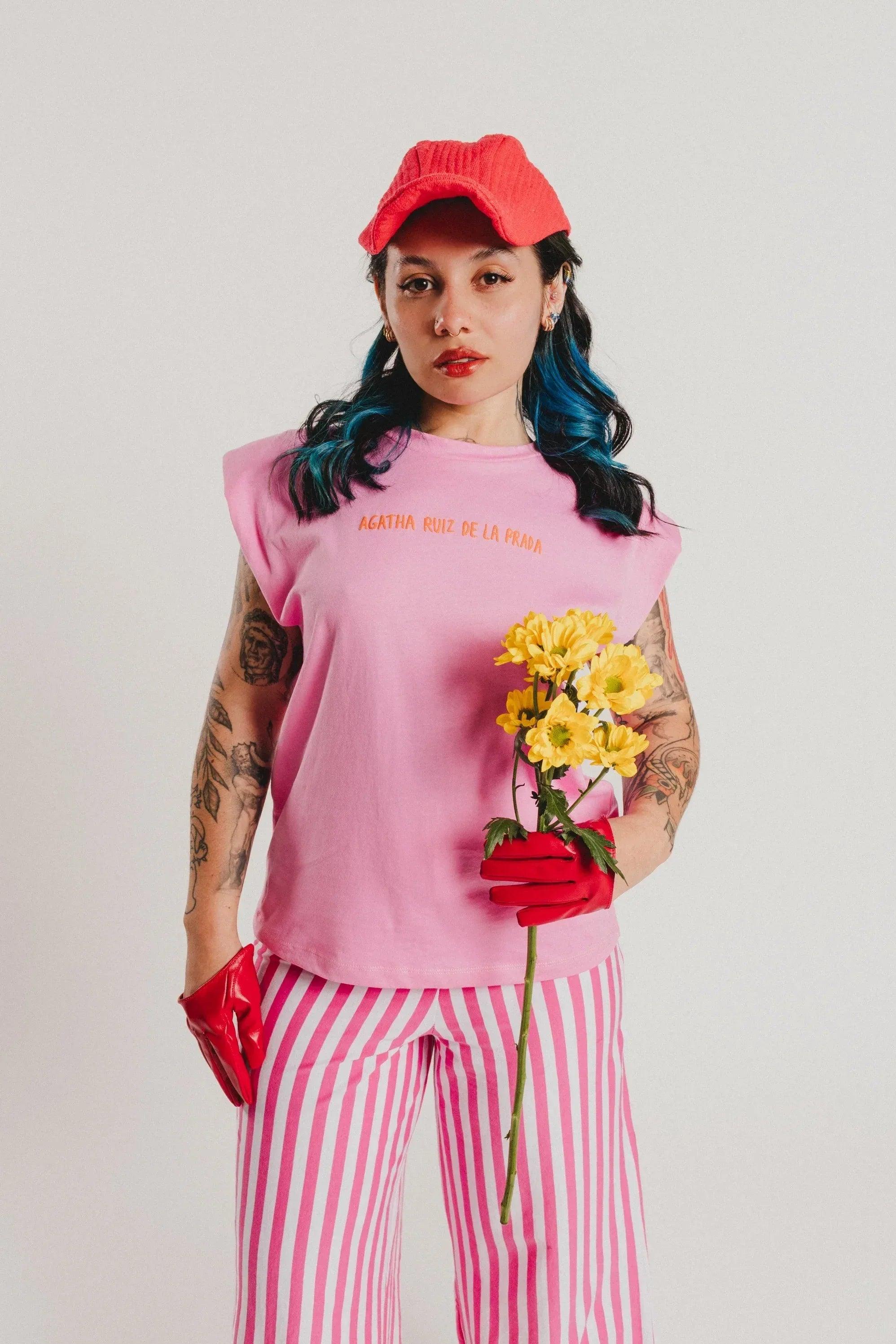 Camiseta rosa de cuello redondo con texto AGATHA RUIZ DE LA PRADA y flores amarillas