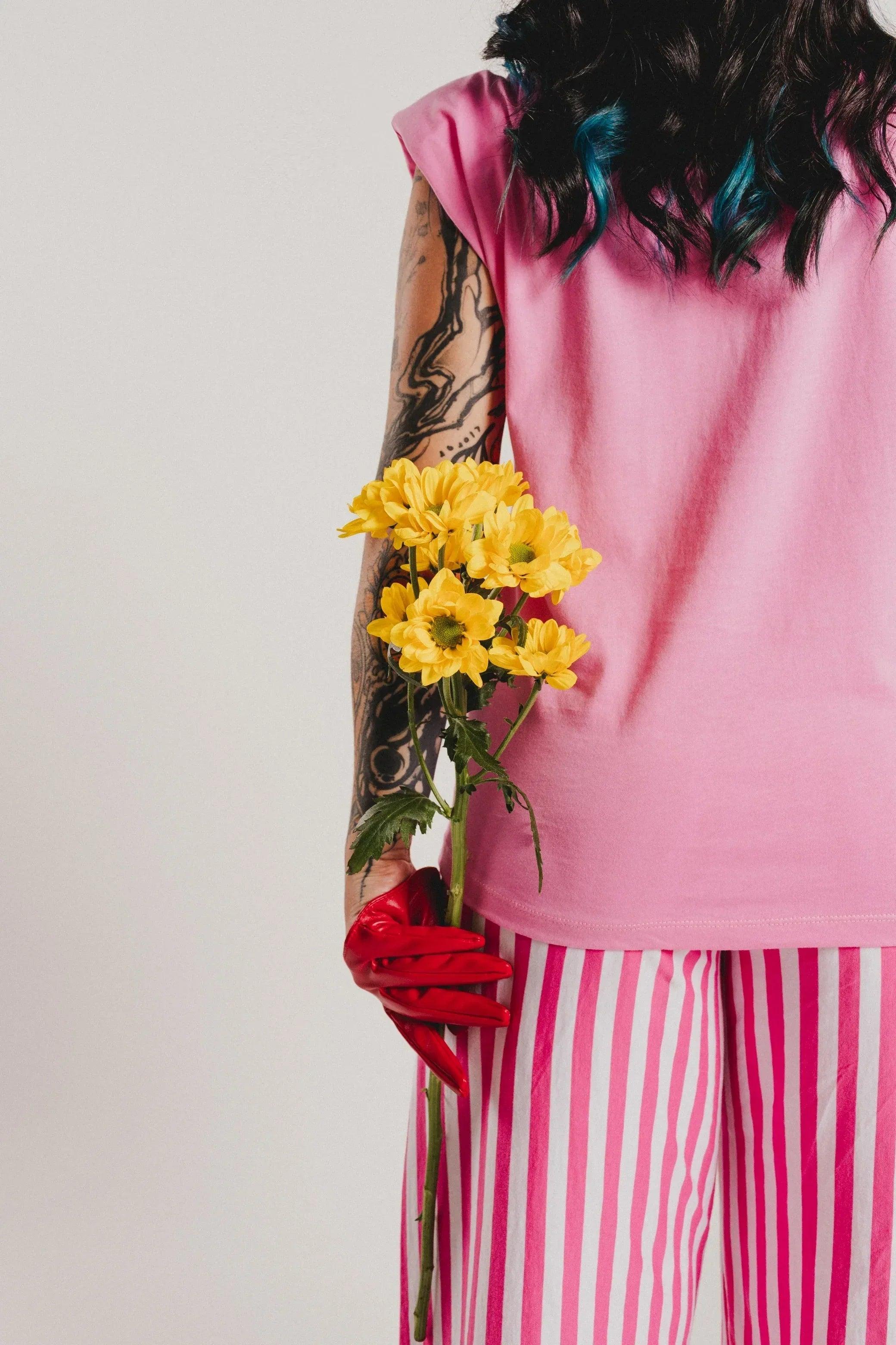 Camiseta rosa con corte de manga corta y estampado de flores amarillas en el pecho