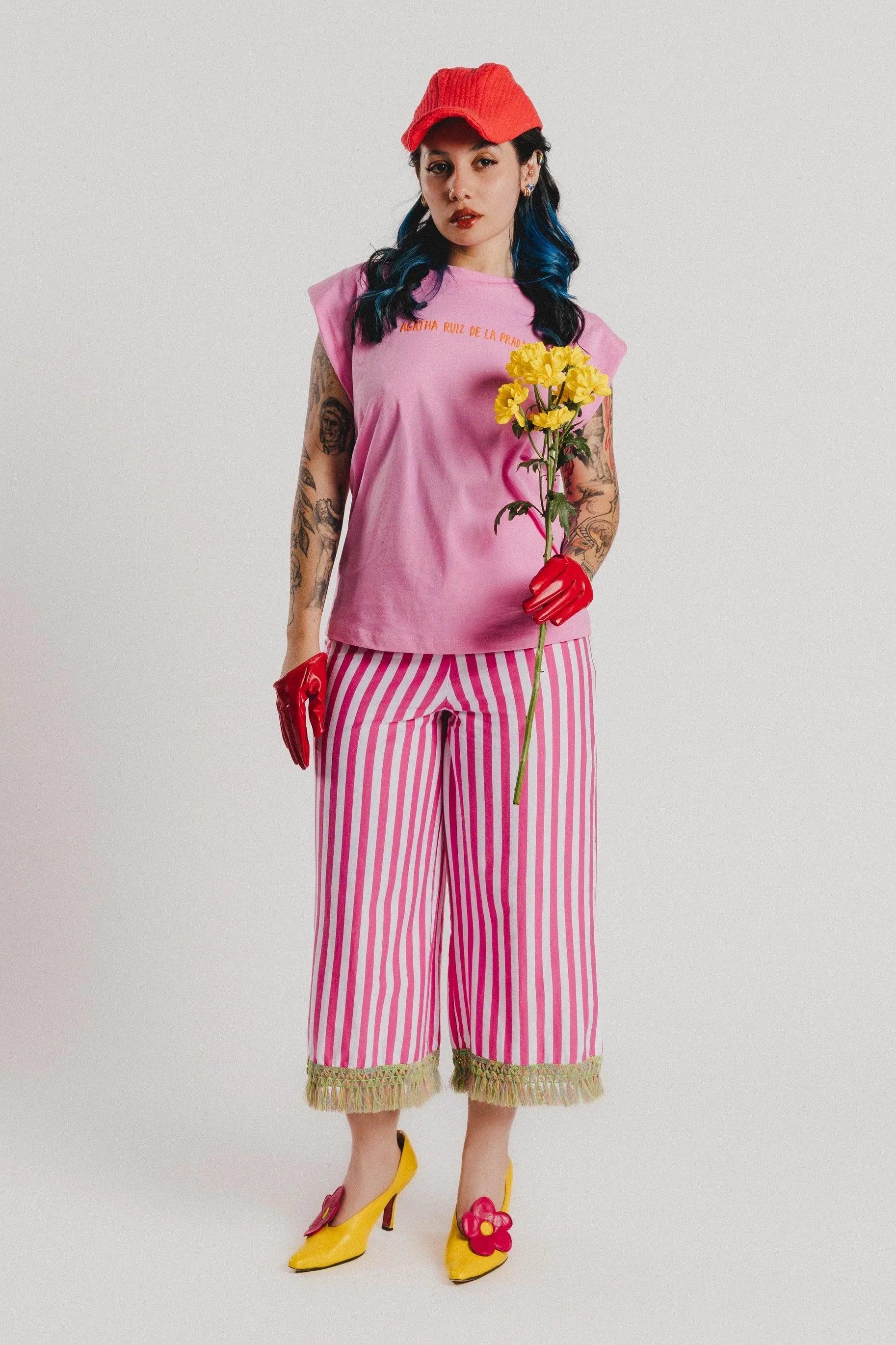 Camiseta rosa con cuello redondo, texto AGATHA RUIZ DE LA PRADA y flores amarillas