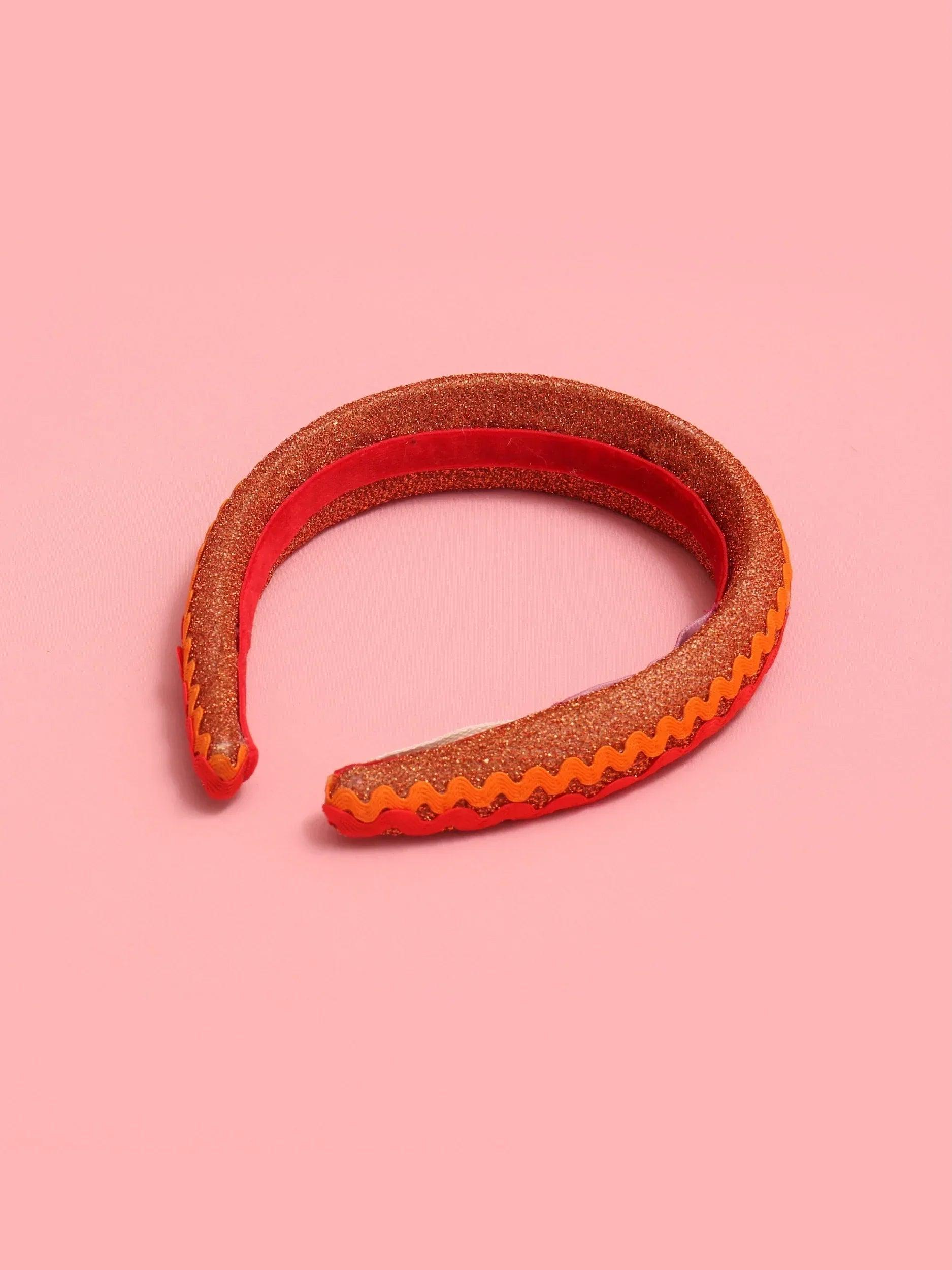Diadema con franja interior marrón y acabado ondulado, patrón zigzag rojo-naranja