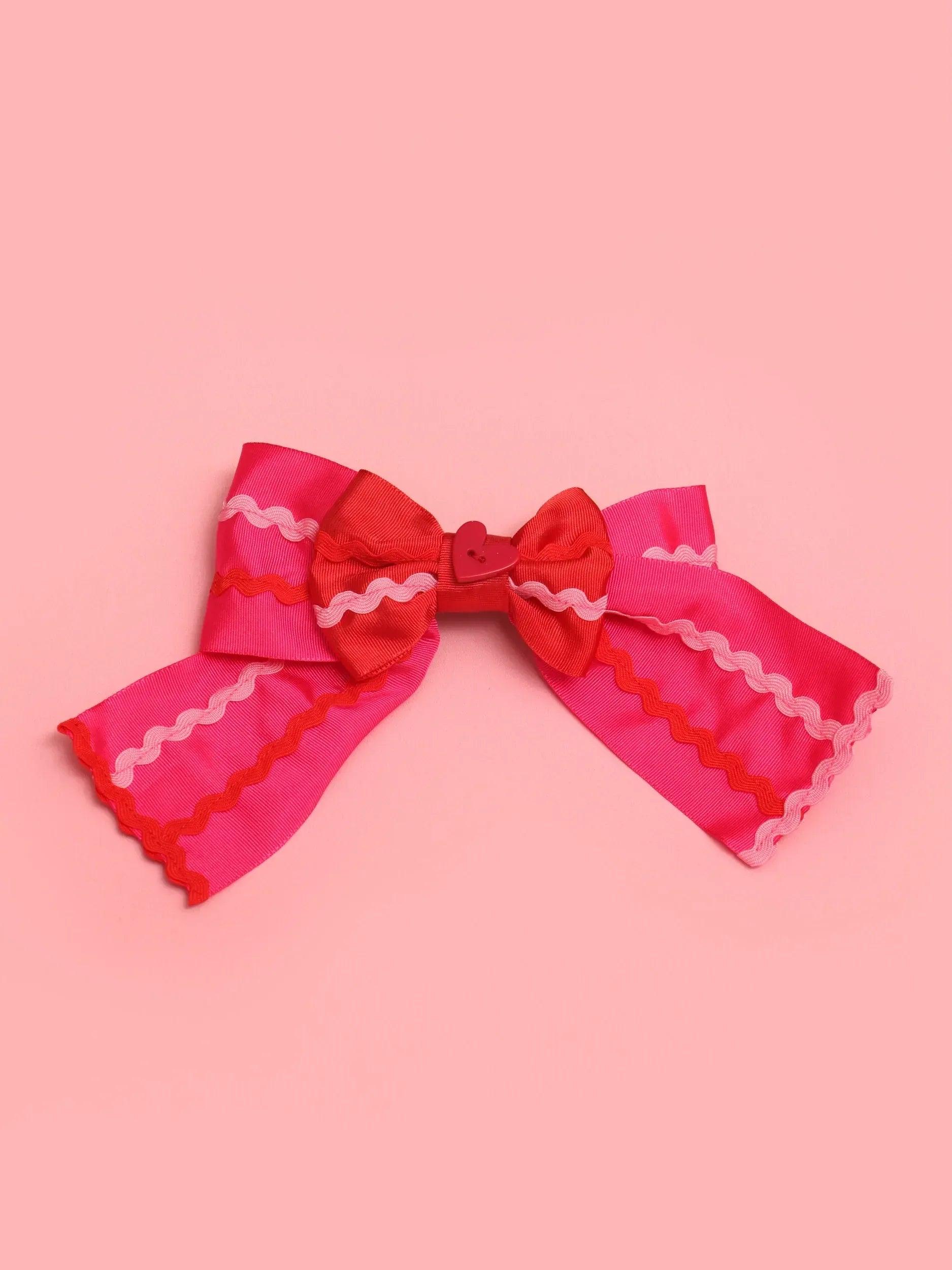 Pasador con lazo rojo y rosa con ondas en cinta