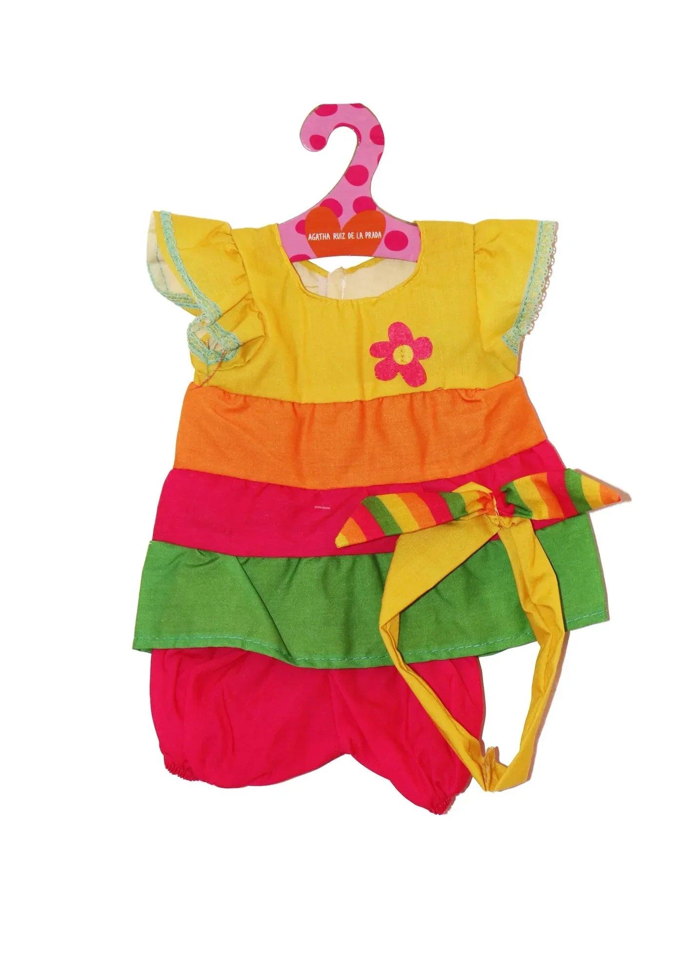 Vestido de muñeca amarillo con volantes, aplique de flor y lazo multicolor.