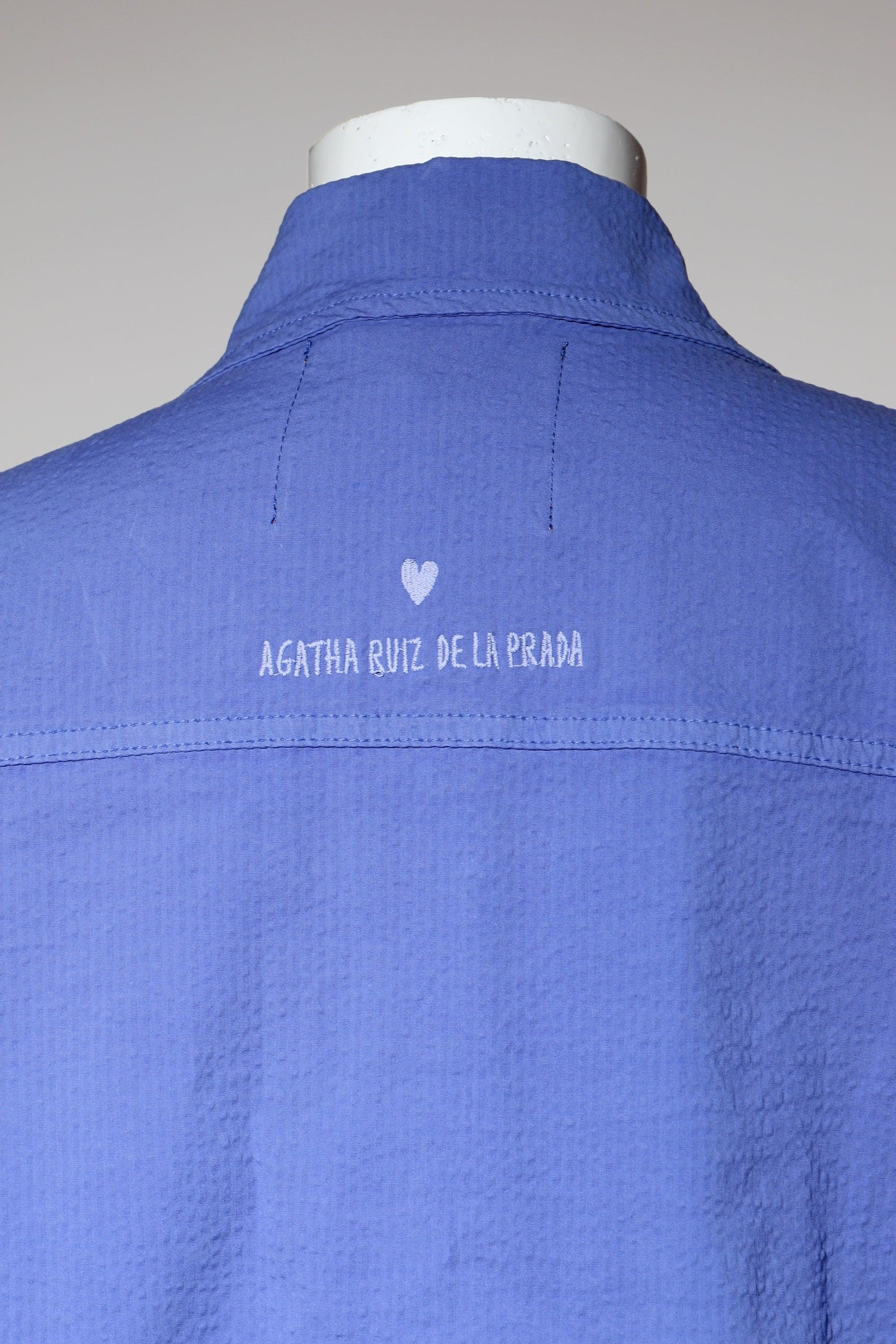 Sobrecamisa morada con etiqueta bordada en la espalda y costuras laterales.