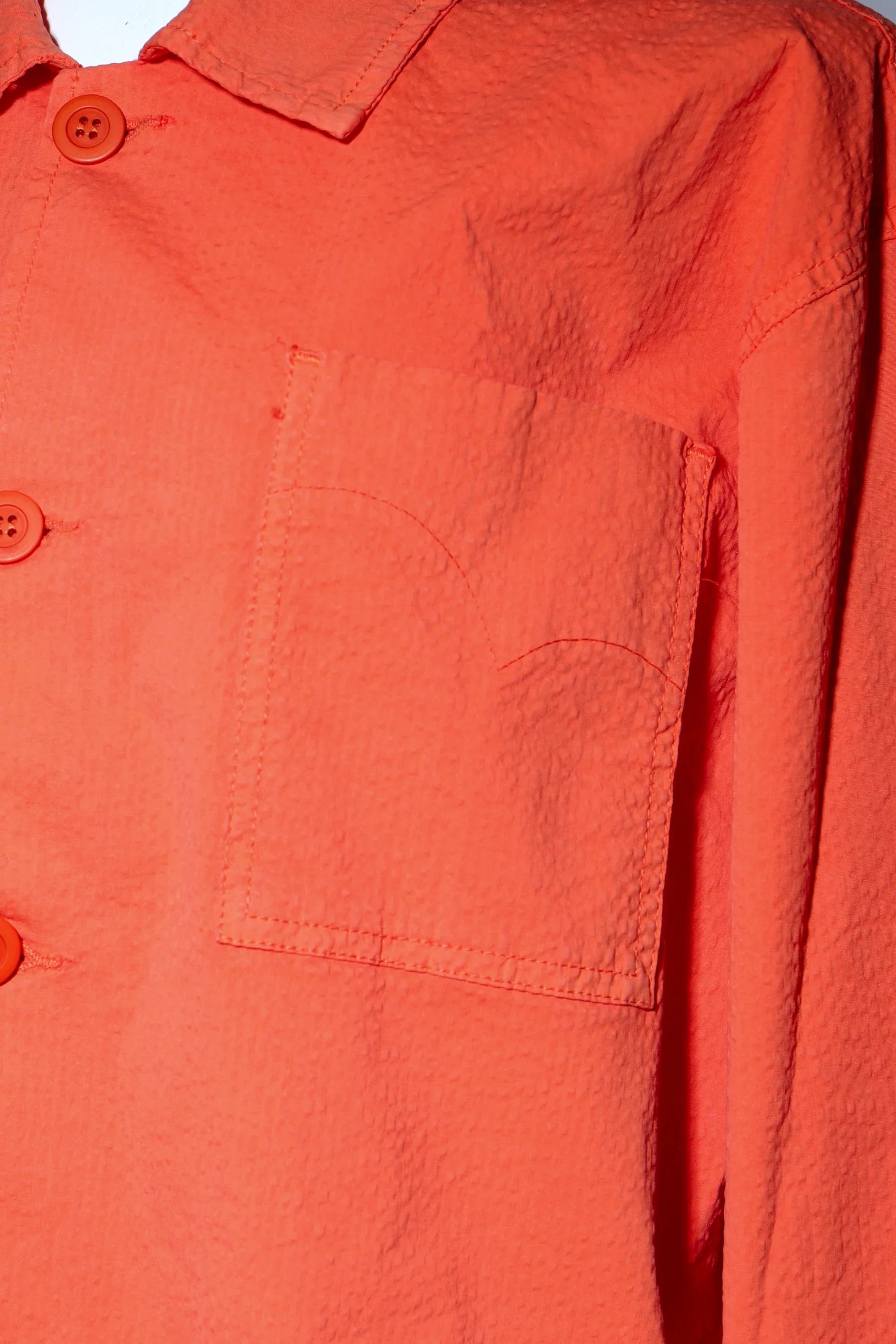 Sobrecamisa naranja: botones y solapa del cuello en primer plano