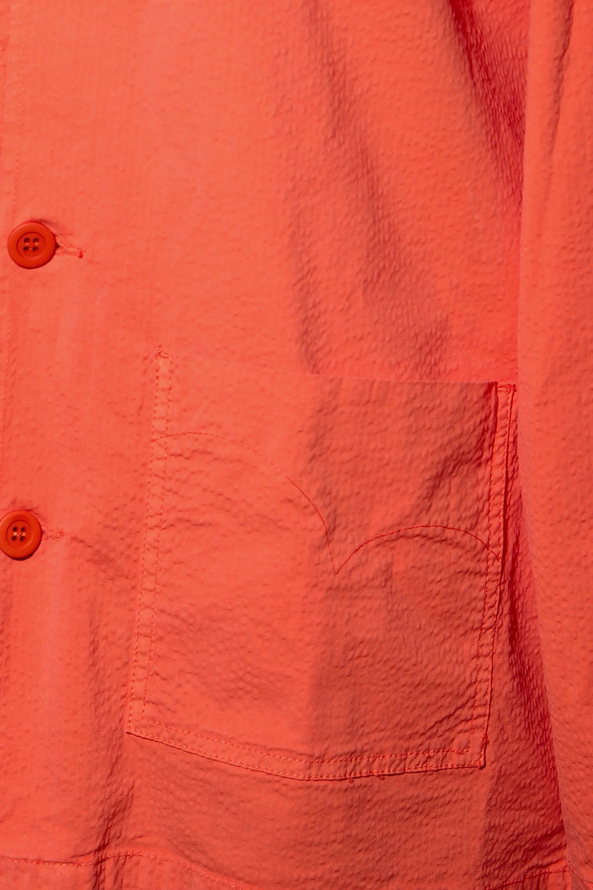 Sobrecamisa naranja con bolsillo frontal y costuras visibles