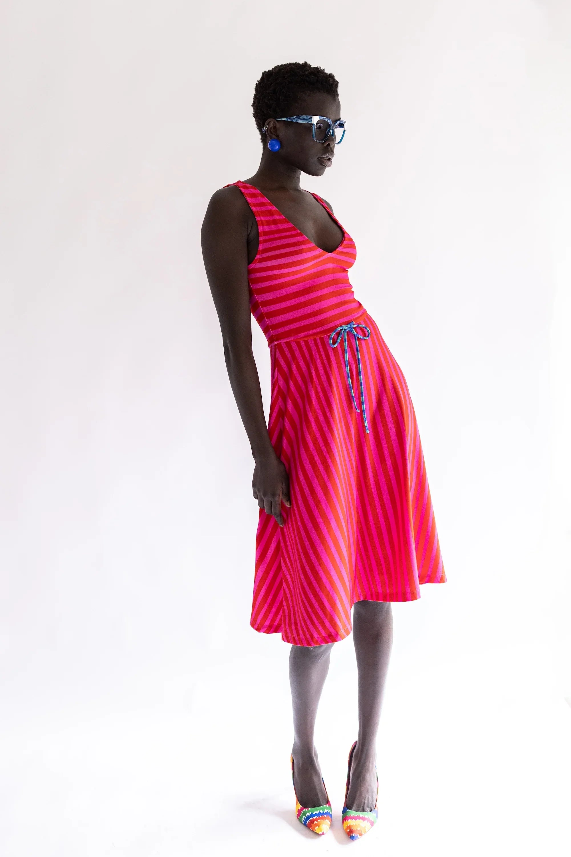 Vestido sin mangas rayado fucsia y rojo con escote en V y lazo central.