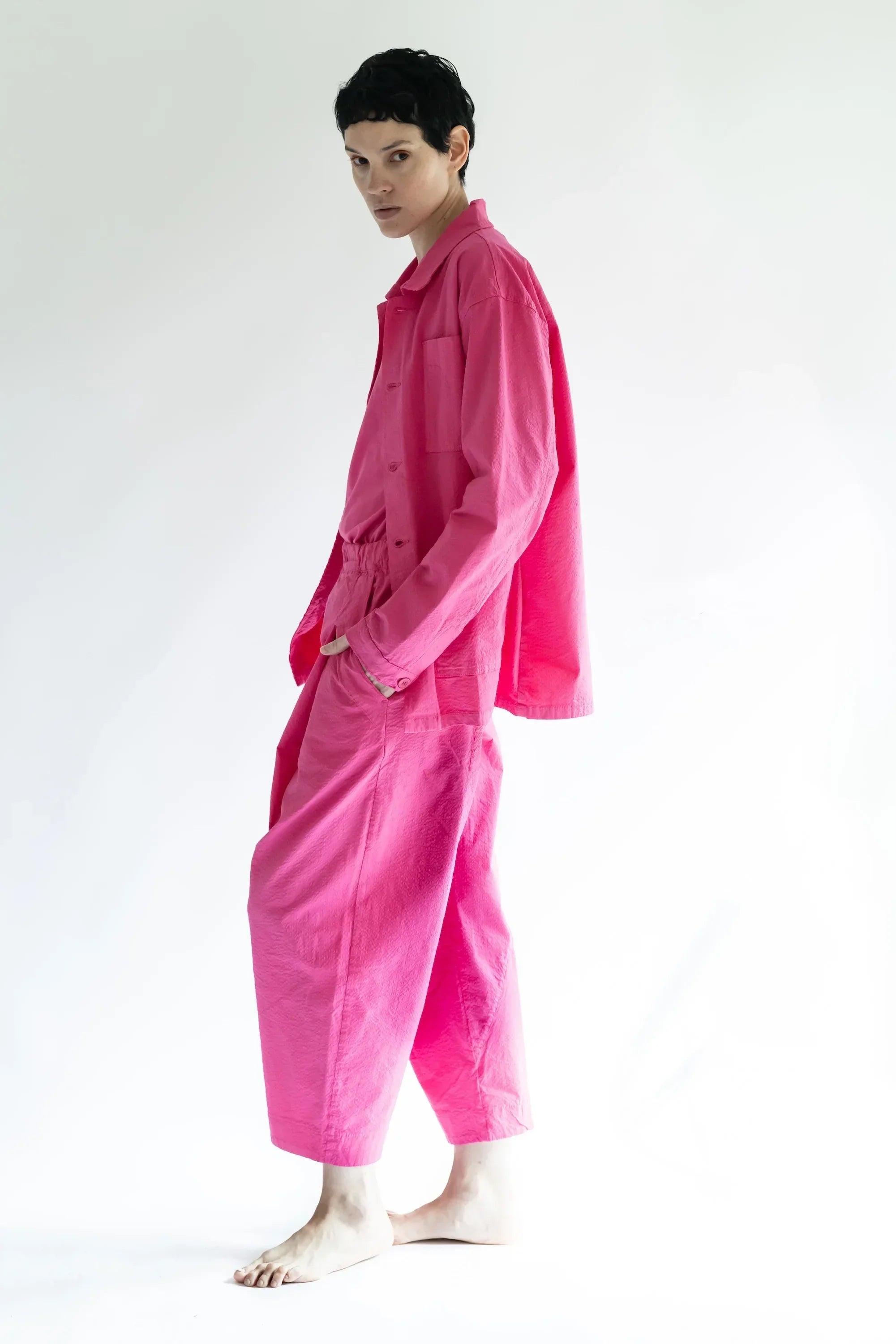 Pantalón fucsia de pierna amplia y cintura elástica, vista lateral con pliegues