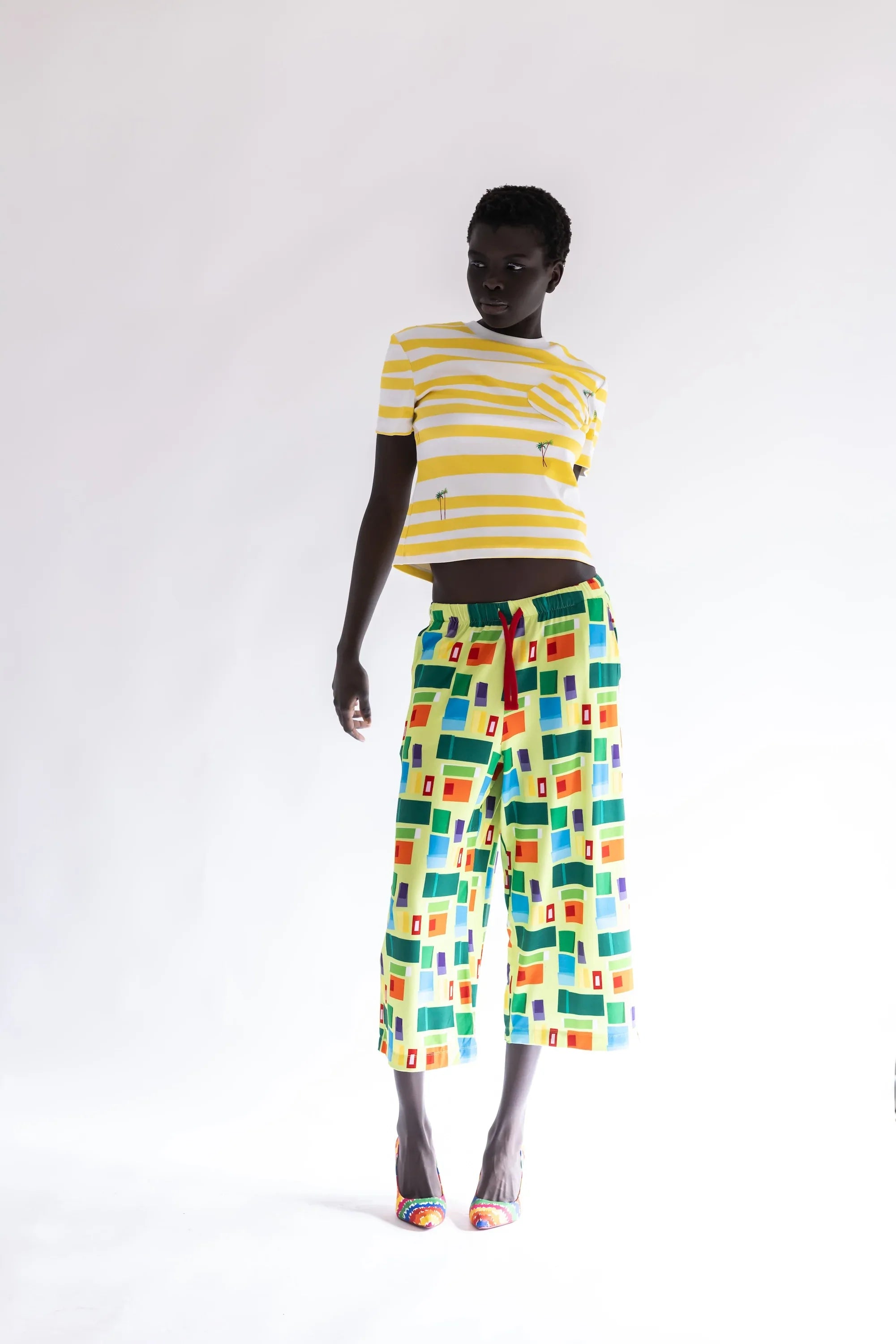 Pantalón largo estampado multicolor con cuadros, vista lateral con pierna amplia.