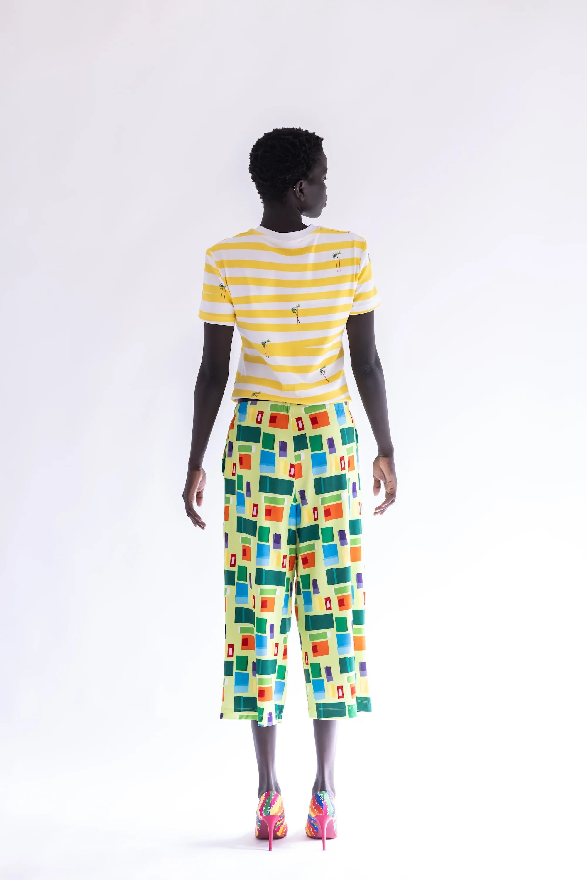 Pantalón largo estampado multicolor con cuadros, vista trasera y pierna amplia.