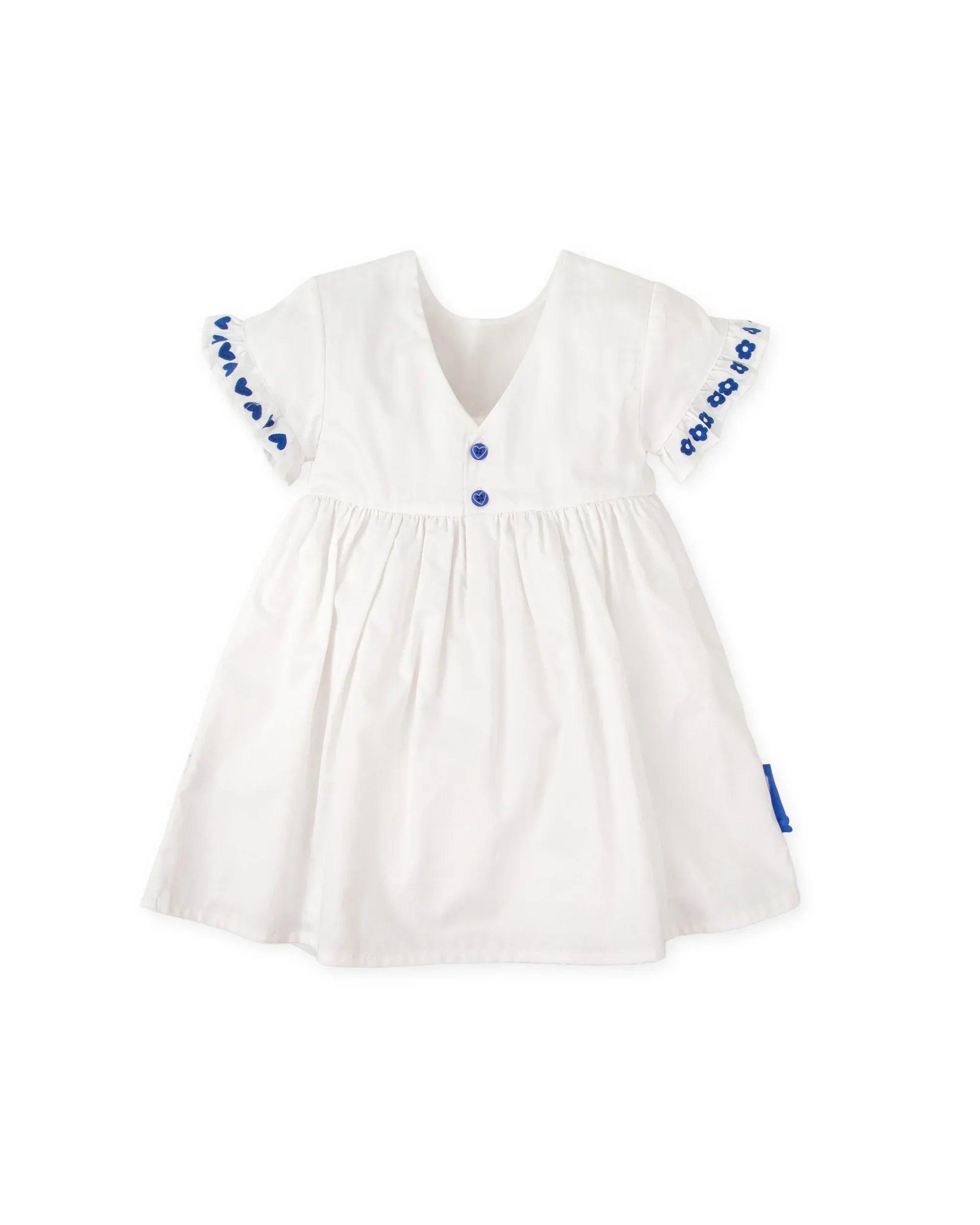 Vestido blanco con cuello redondo y botones azules, mangas abullonadas y vuelo