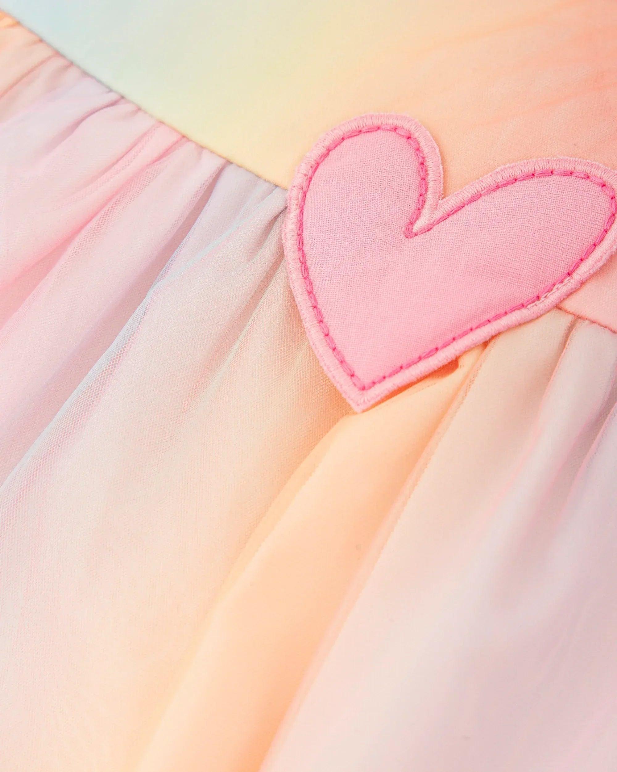 Detalle de corazón rosa bordado en el vestido de tul con capas multicolor