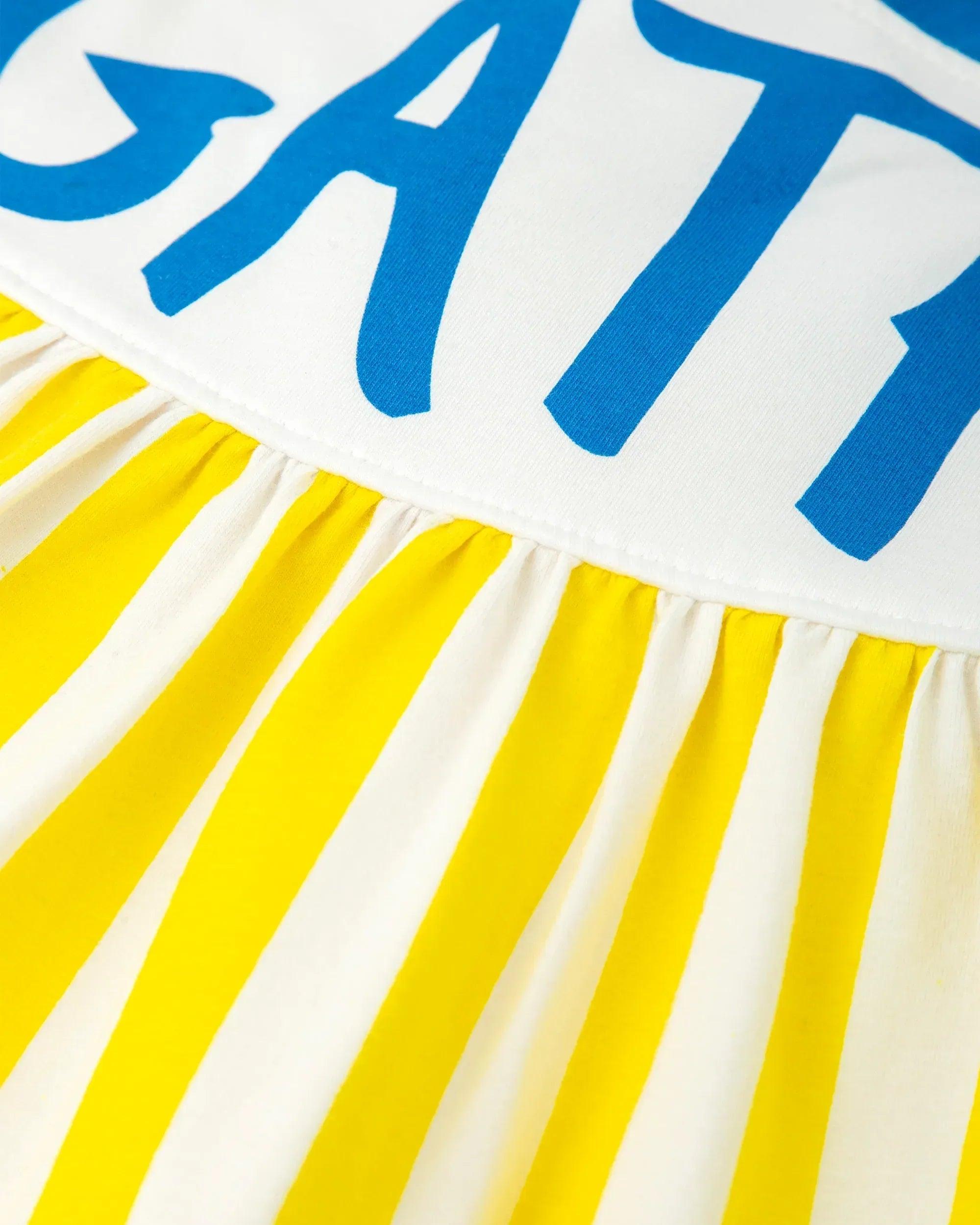 Parte superior del vestido a rayas amarillo y blanco con tirantes azules y texto AGATHA.