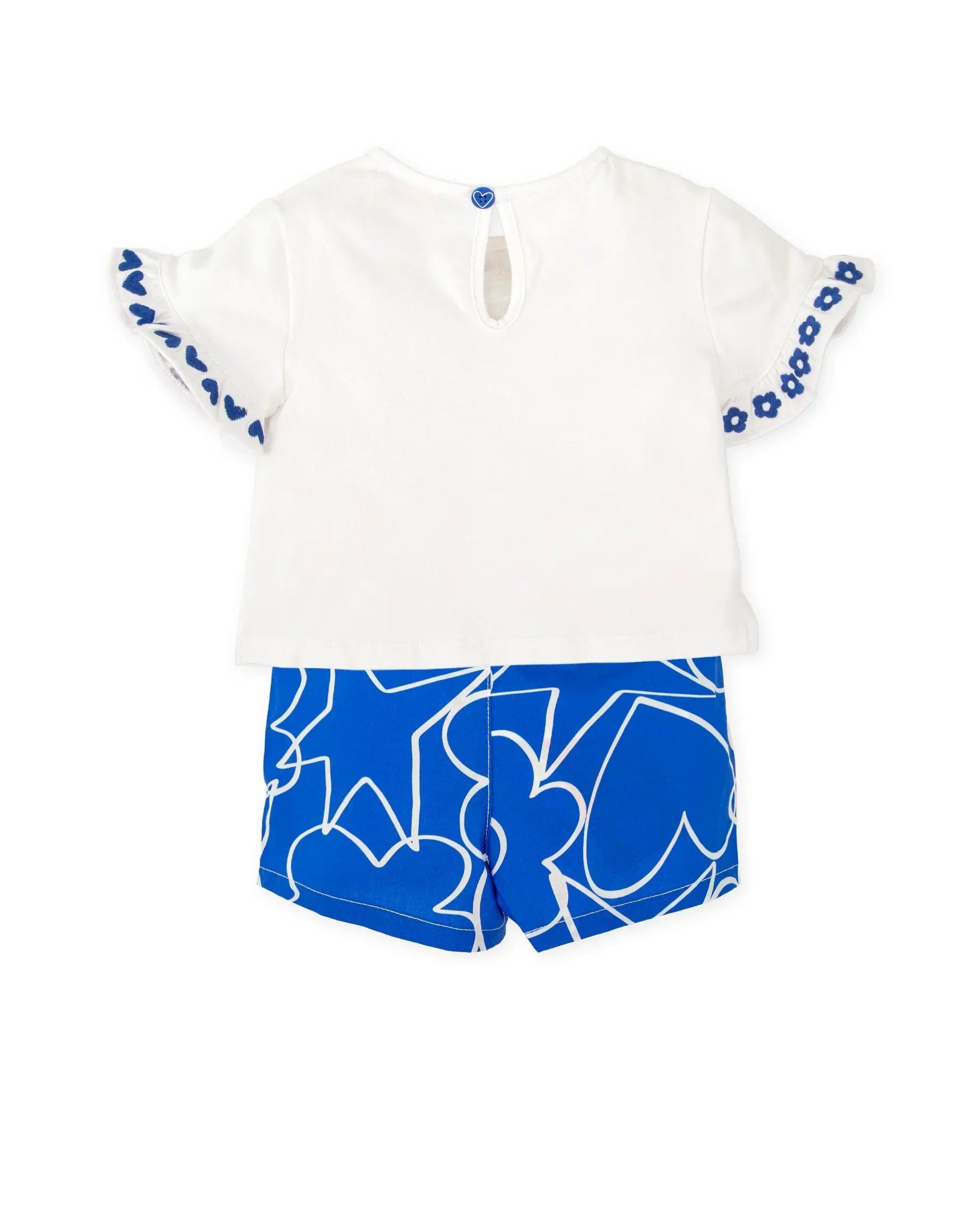 Conjunto de camiseta blanca con abertura central y shorts azules con dibujo abstracto