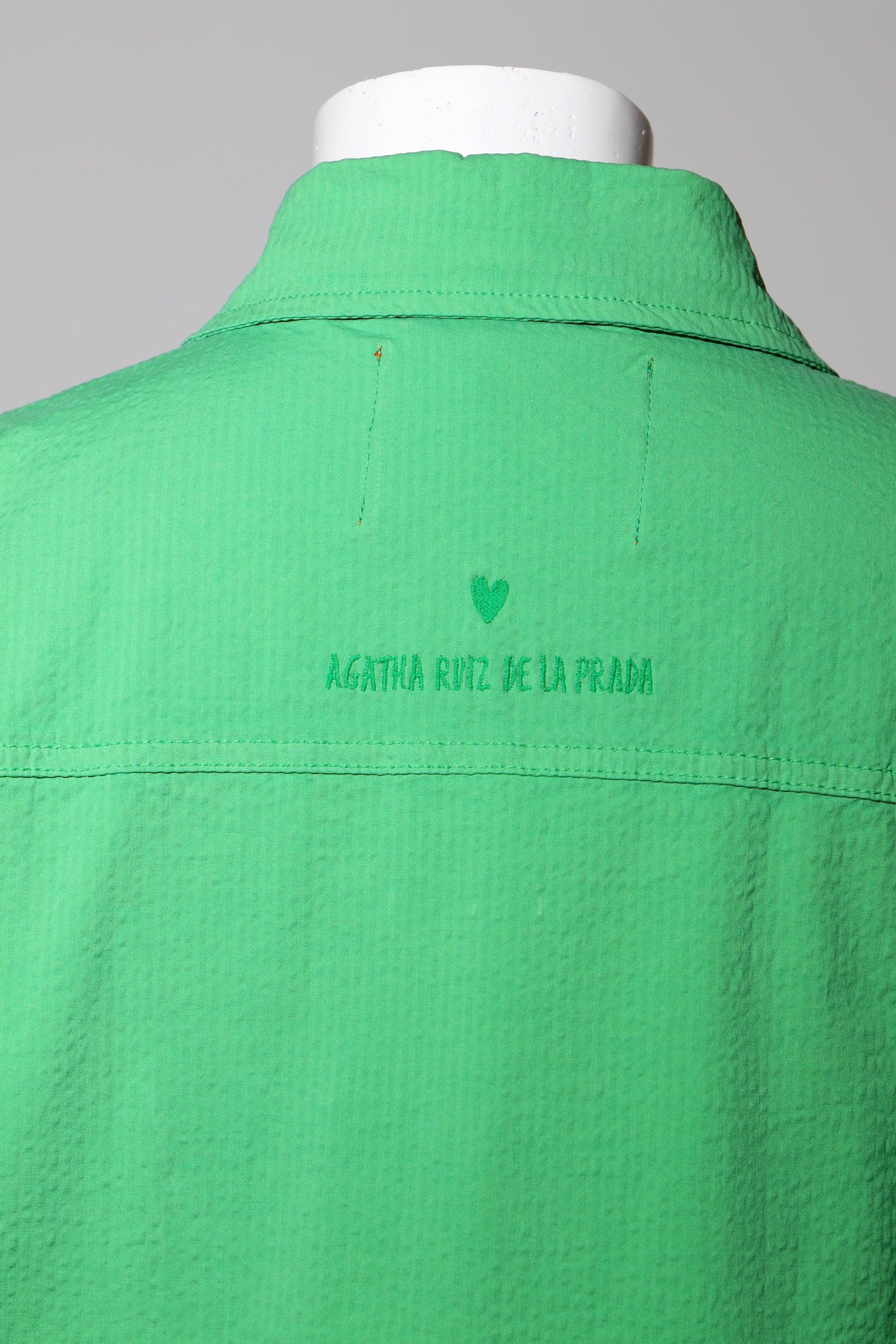 Sobrecamisa verde con costura central y texto bordado en la espalda